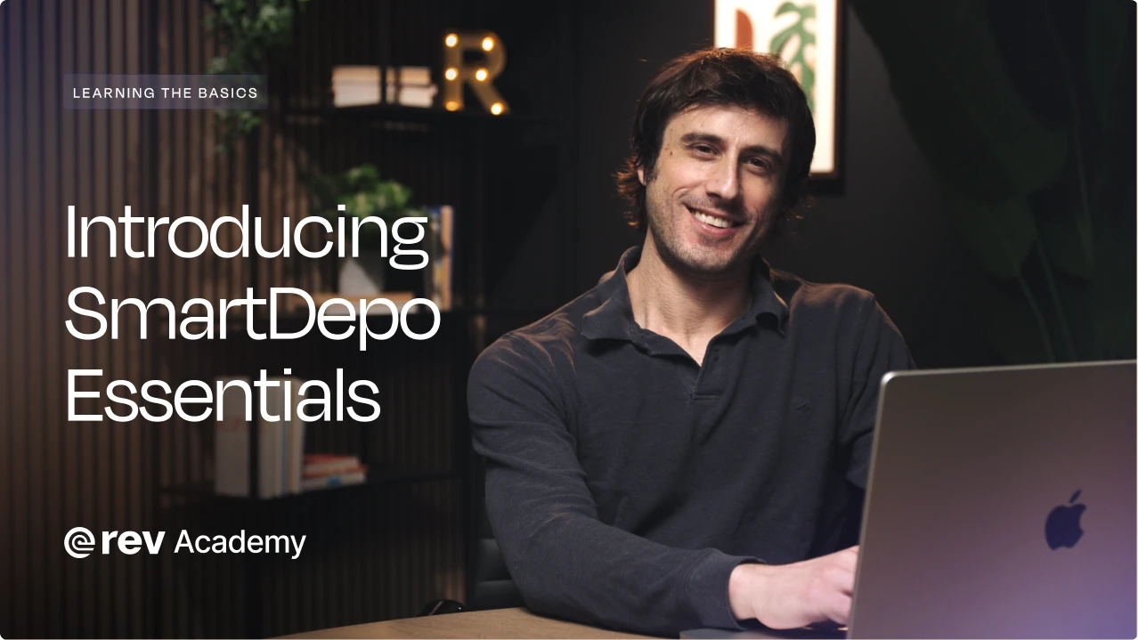 Smiling man sitting at a desk with a laptop, text on left reads 'Introducing SmartDepo Essentials @rev Academy'.