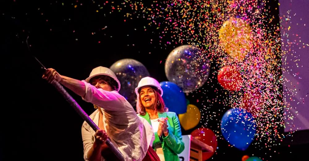 Theatre Cedar Rapids executive director Katie Hallman spreads confetti with a shovel during a 100th anniversary celebration and renovation groundbreaking ceremony at Theatre Cedar Rapids in Cedar Rapids, Iowa on Tuesday, Aug. 12, 2025. (Nick Rohlman/The Gazette)