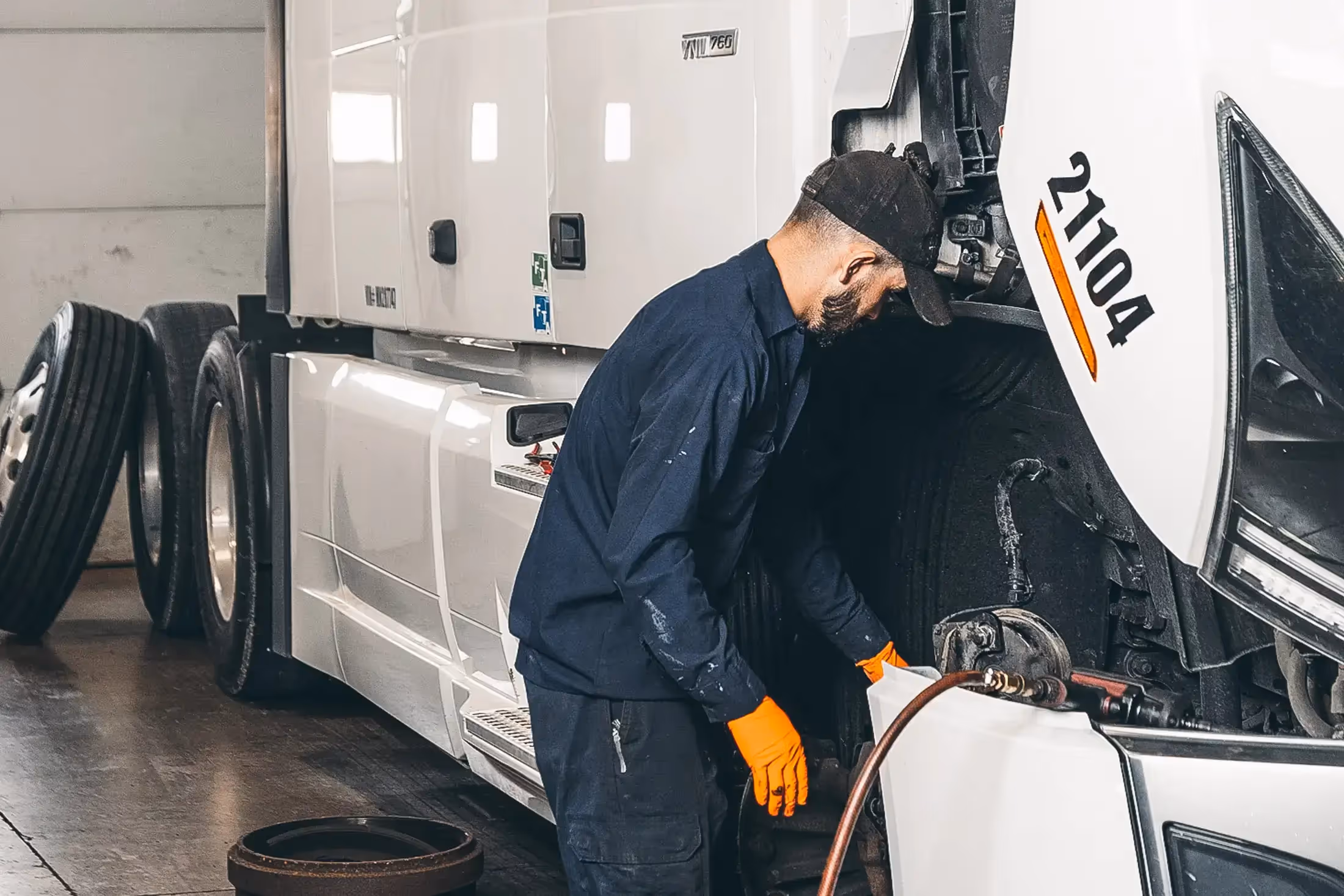 Mechanic performing PM service on semi truck fleet