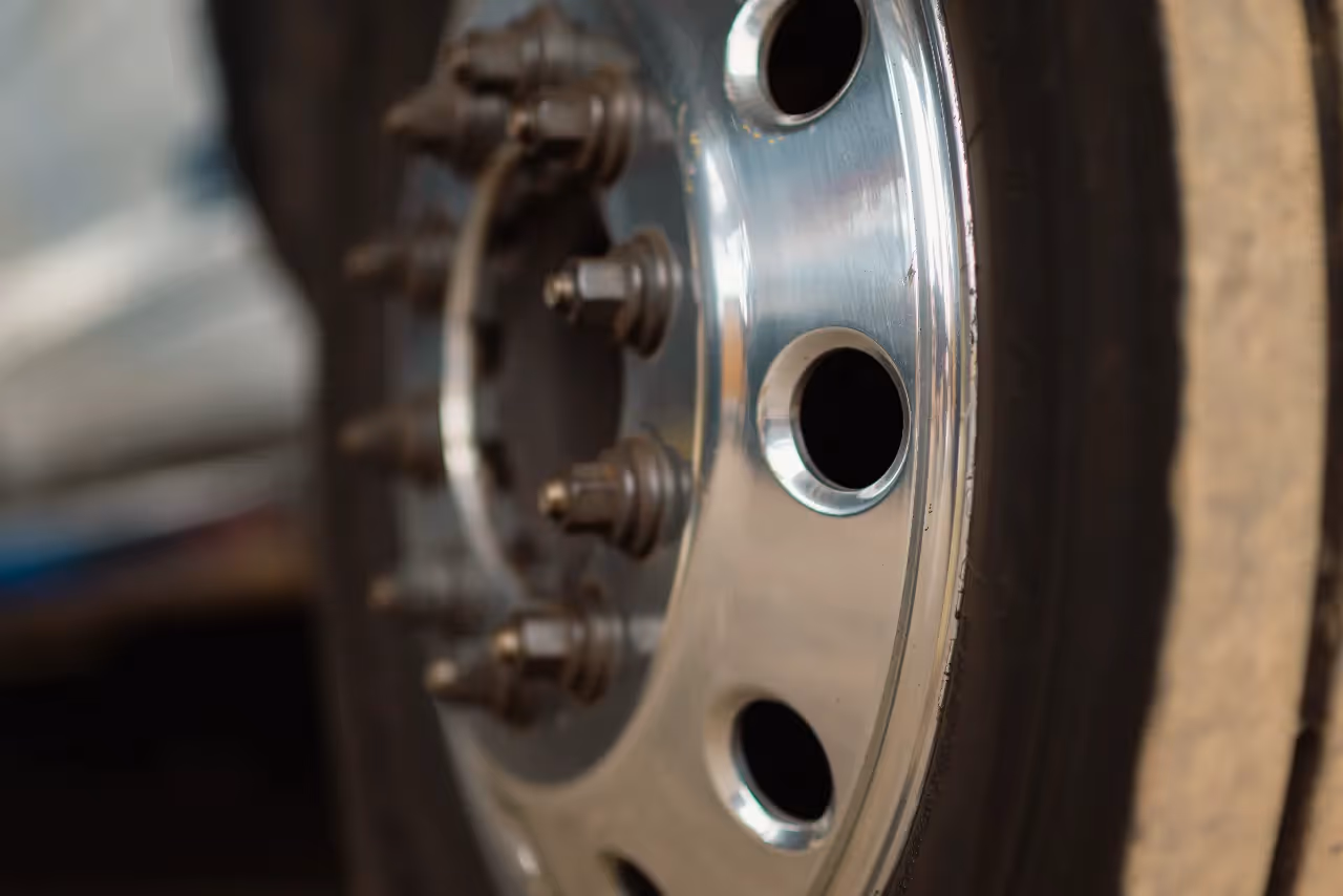 Close-up of a heavy-duty truck wheel showing clean chrome hub cover and multiple lug nuts.