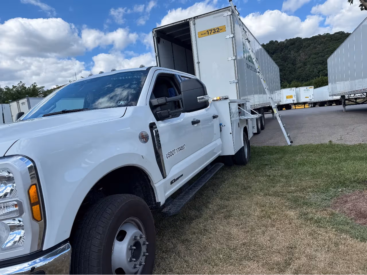 Mobile fleet service truck parked beside a box trailer with ladder access, showing USDOT 1703957 and ALMZ 1732 pv text.
