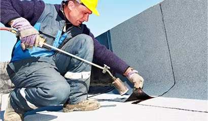Ecoshield Exteriors roofer working on a commercial building roof located in downtown denver