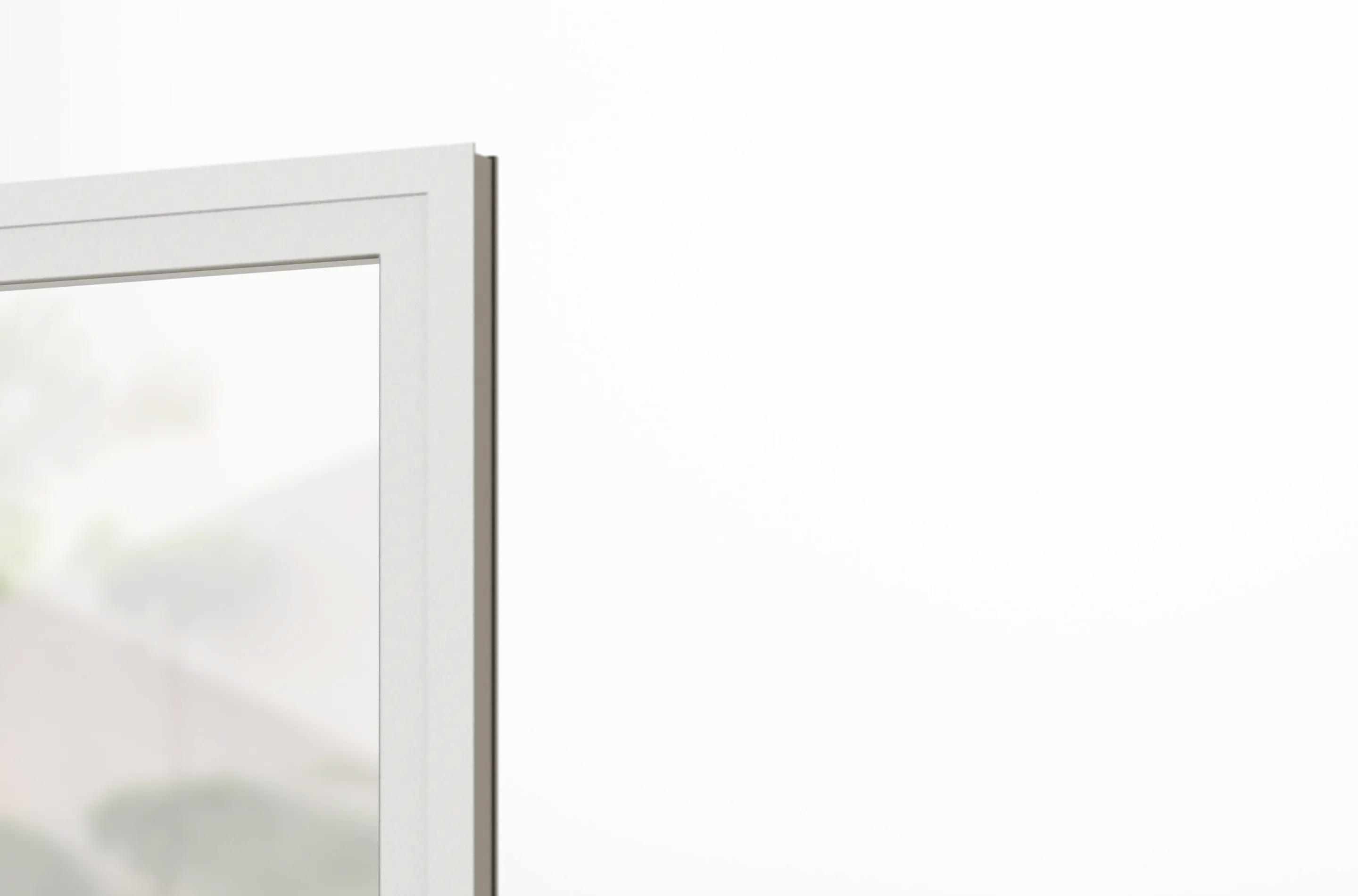 Nahaufnahme einer weißen Fensterrahmenecke mit unscharfem Haus und grünen Büschen im Hintergrund.