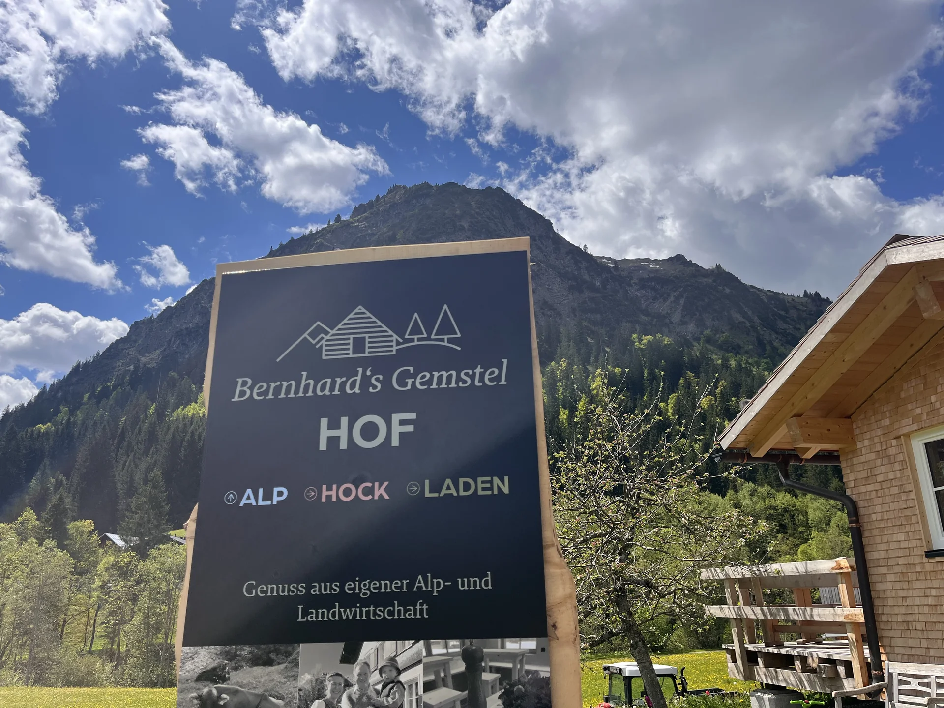 Schild Bernhard's Gemstel Hof – Alp, Hock, Laden – vor Bergkulisse im Gemsteltal