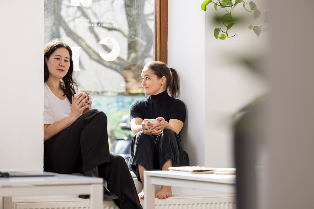 Portrait der beiden Designerinnen Asuka Grün und Julia Weikinn im Fenster des Münchner Studios.
