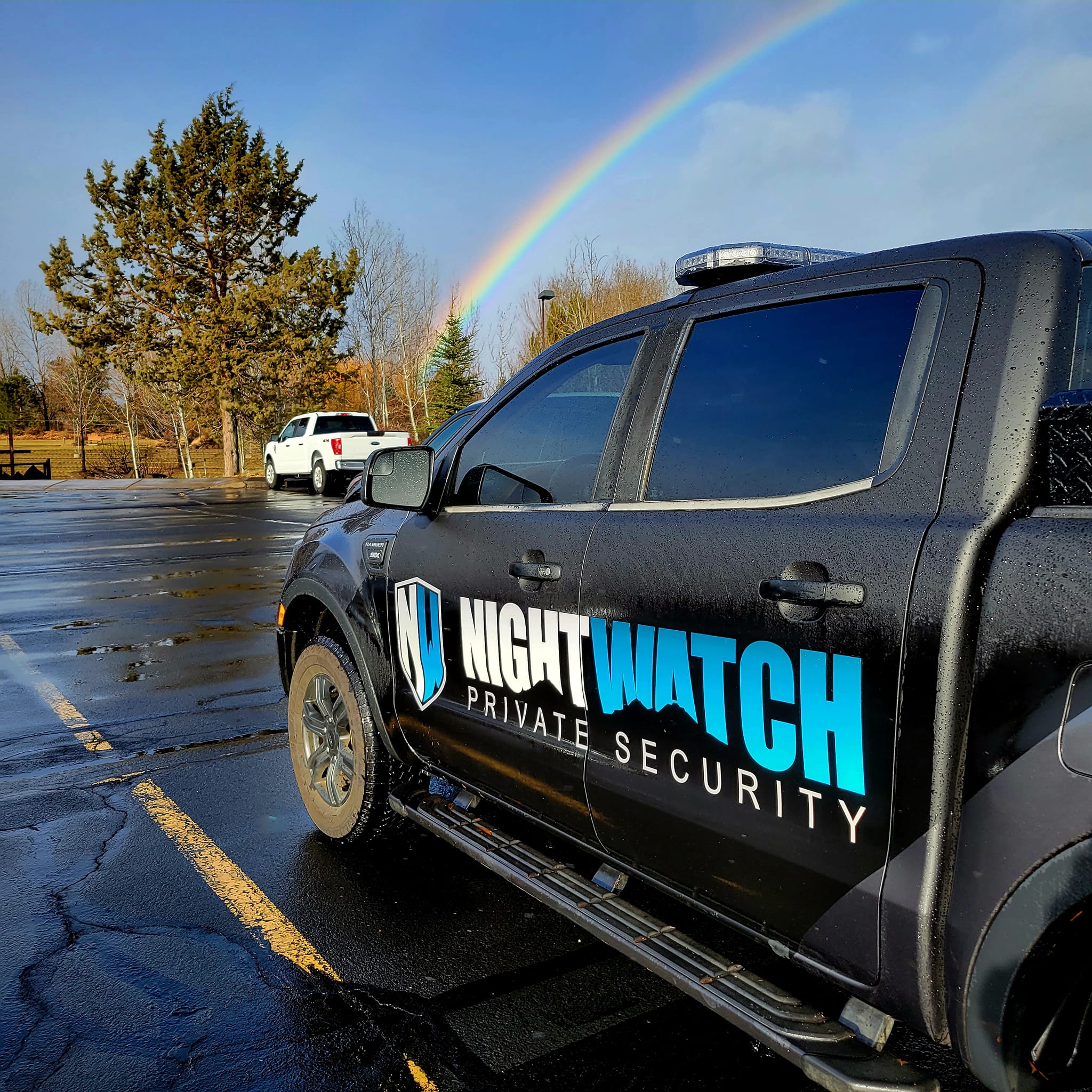 A truck parked under a rainbow.