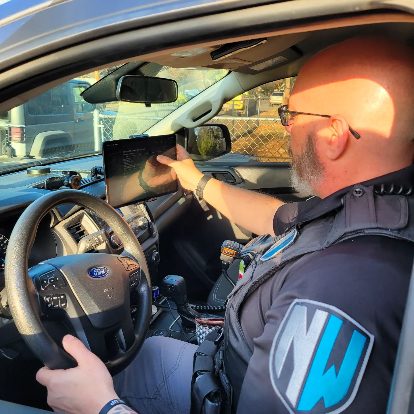 A security guard in his truck using an ipad.