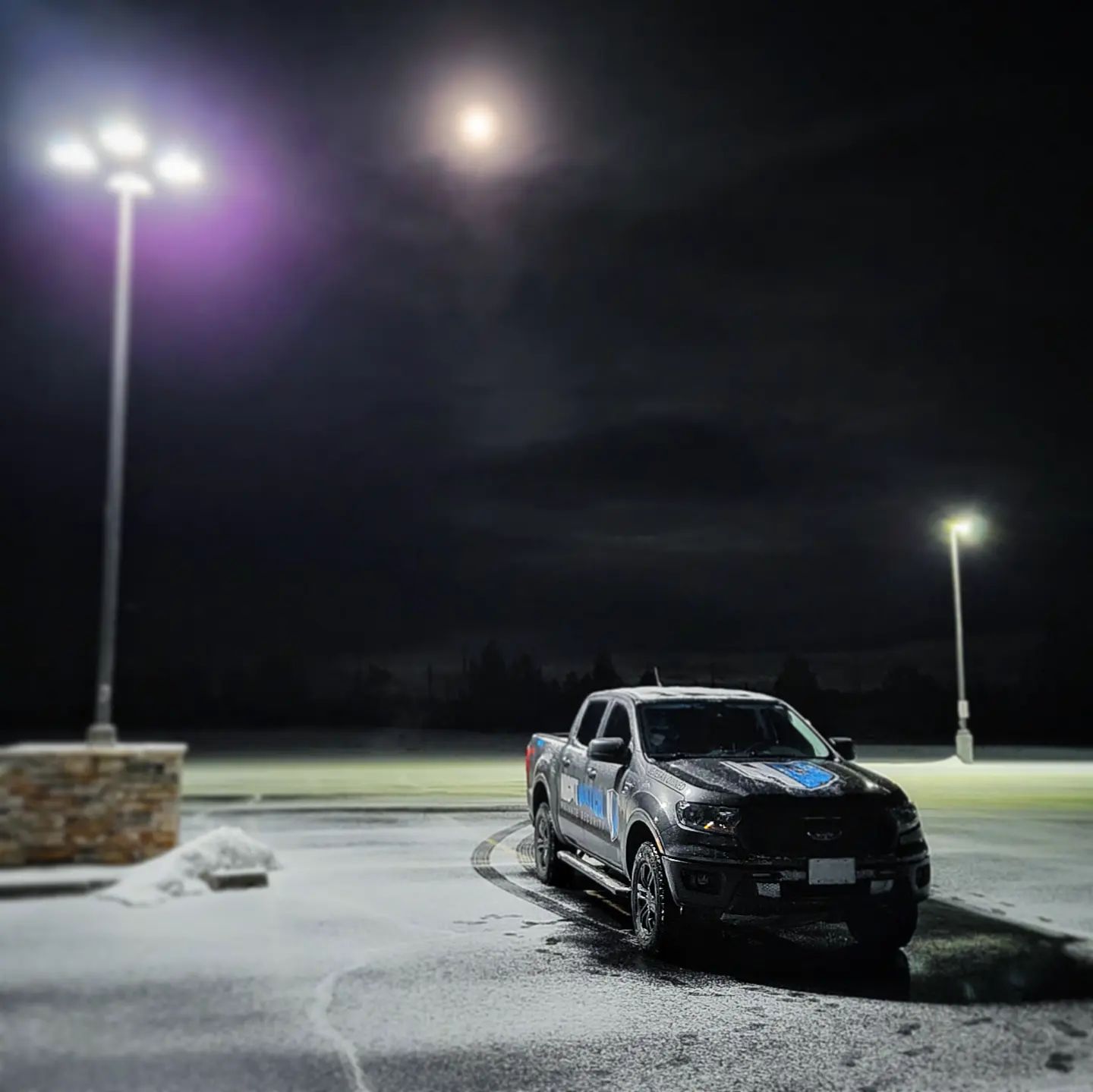 A truck parked in a parking lot under some street lights.