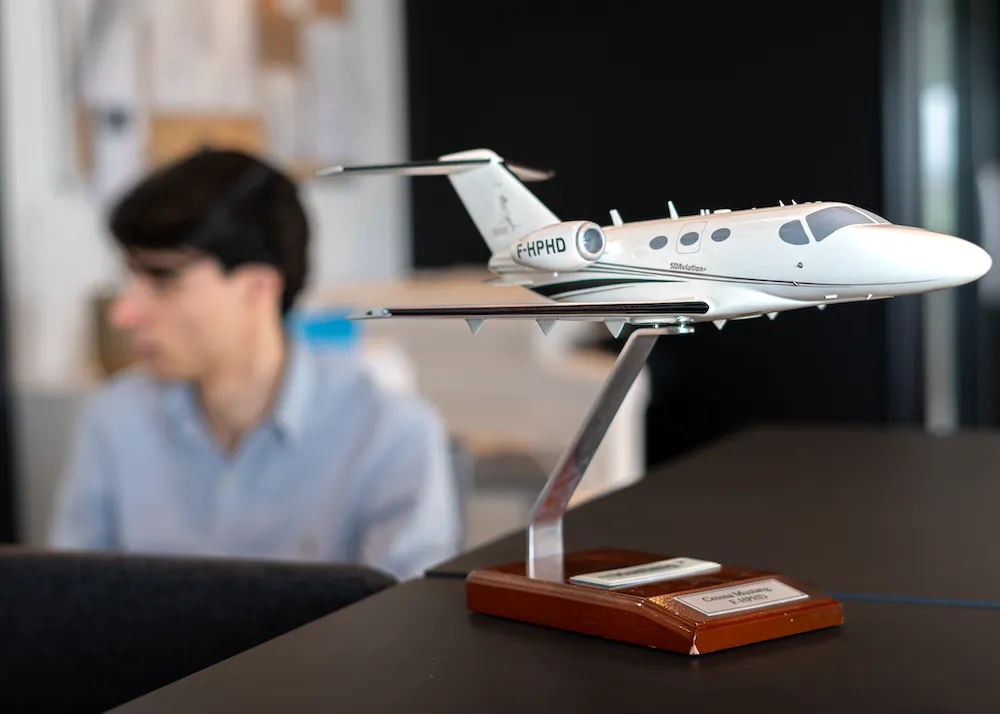 maquette d'avion au premier plan posée sur un bureau