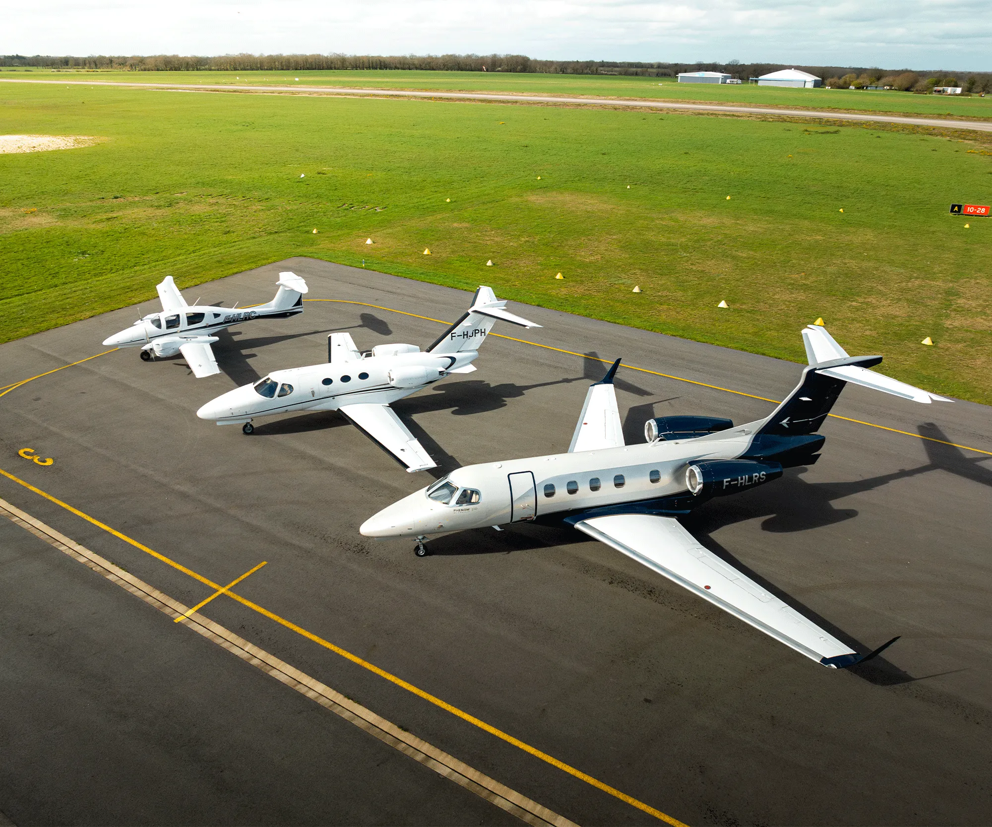 photo vue sur le tarmac de 3 jets (DA62, Cessna citation Mustang, Phenom 300) pris en drone sur le côté droit