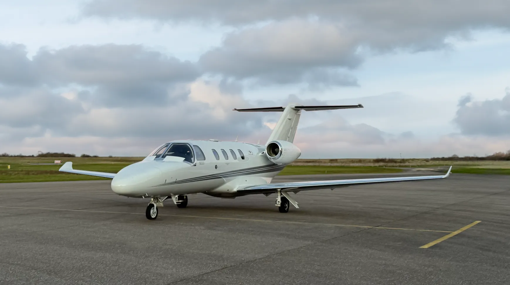 Cessna citation M2 au sol sur le tarmac, avec un ciel nuageux