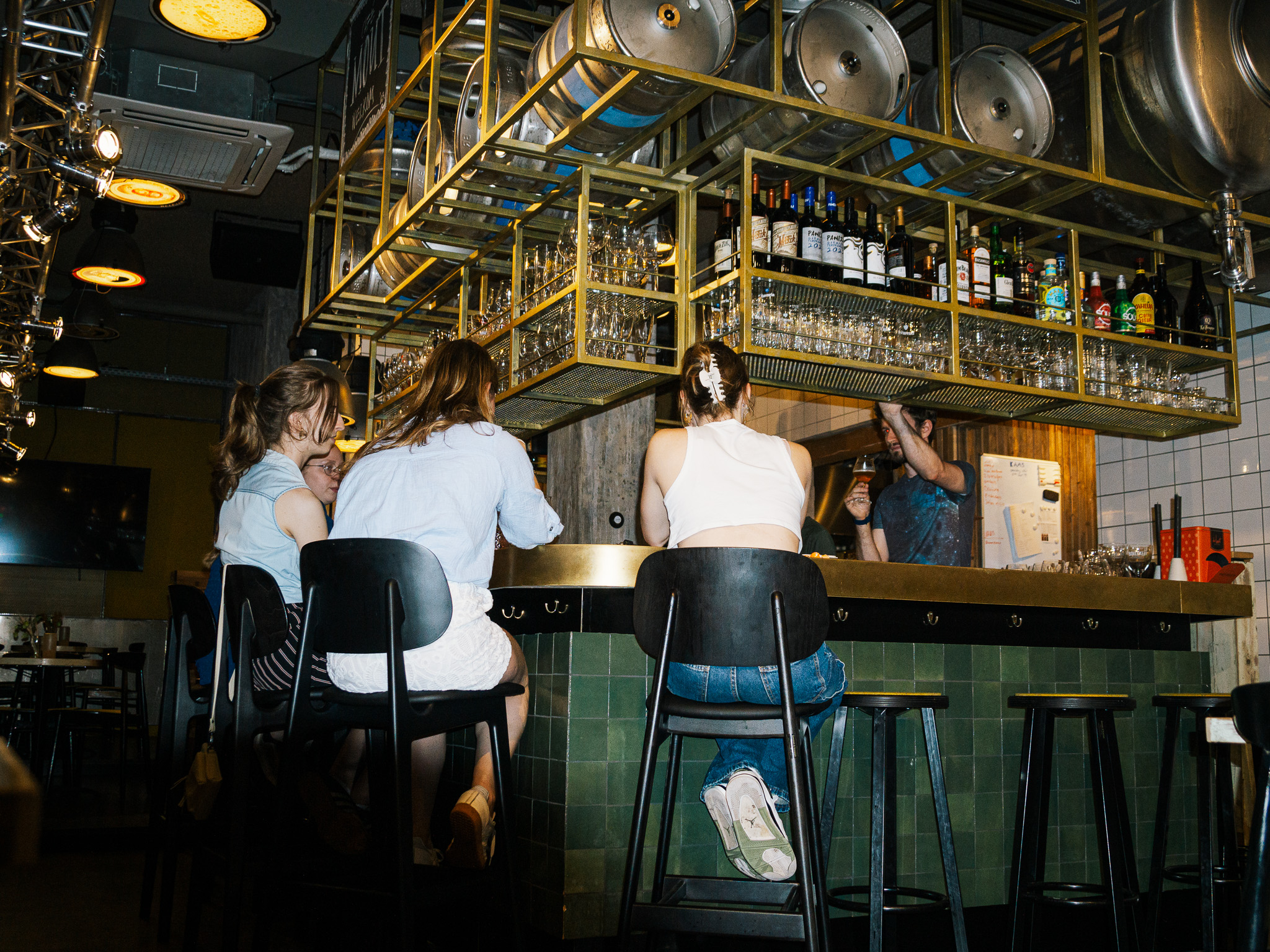 Gasten aan de bar met de barman en glazen op de achtergrond