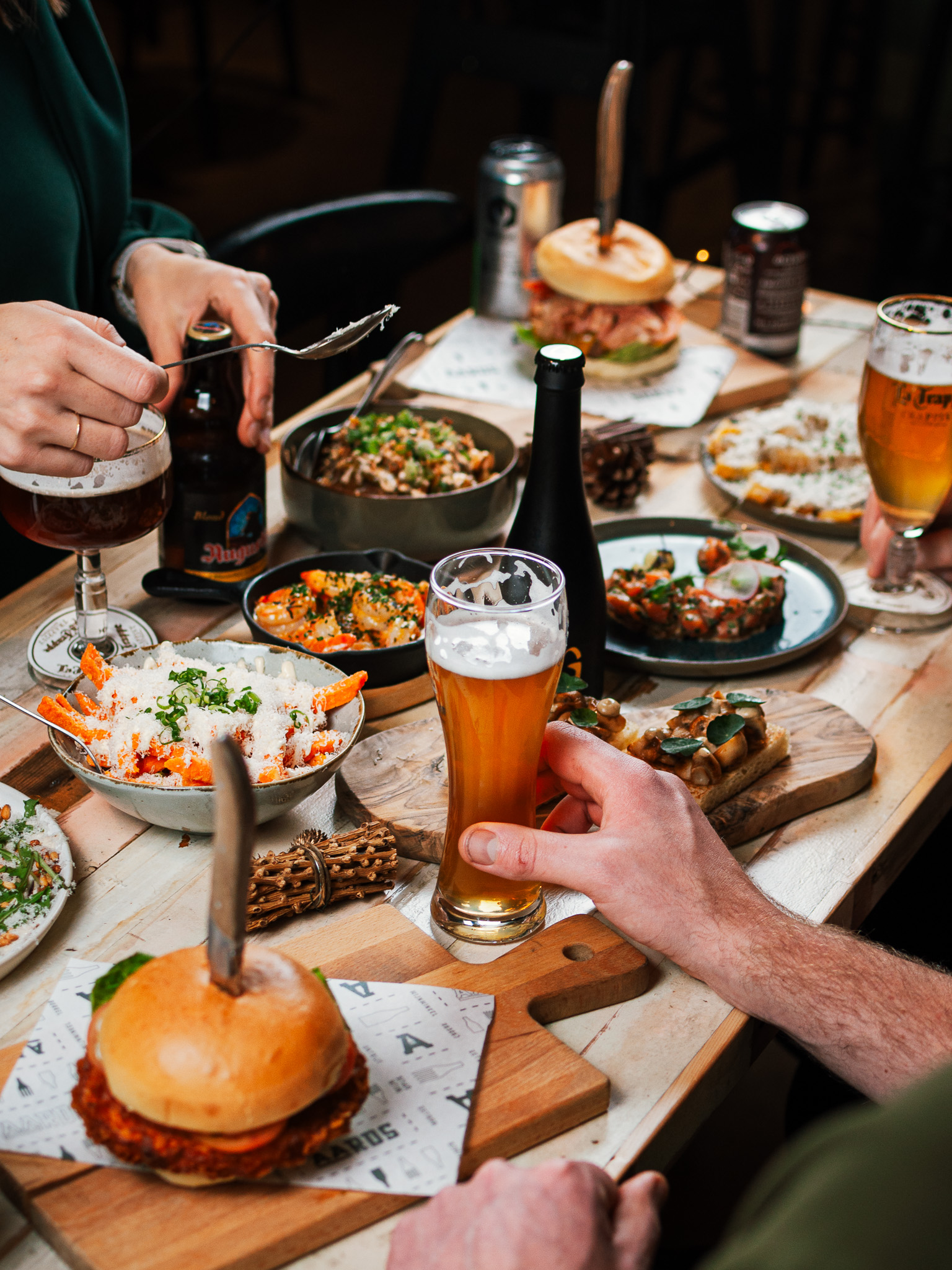 Tafel vol burgers, bites en glazen speciaalbier