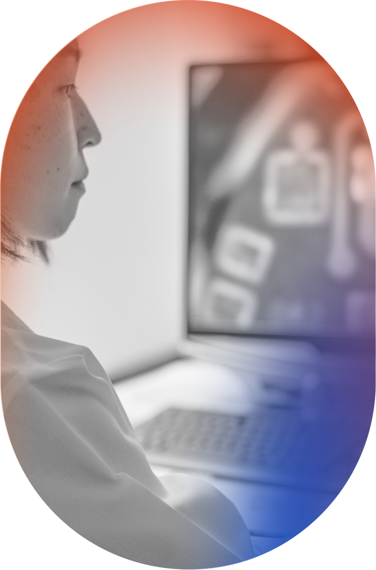 A female neuroscientist reviewing the Connexus Brain-Computer Interface Cortical Module on a computer screen using a microscope