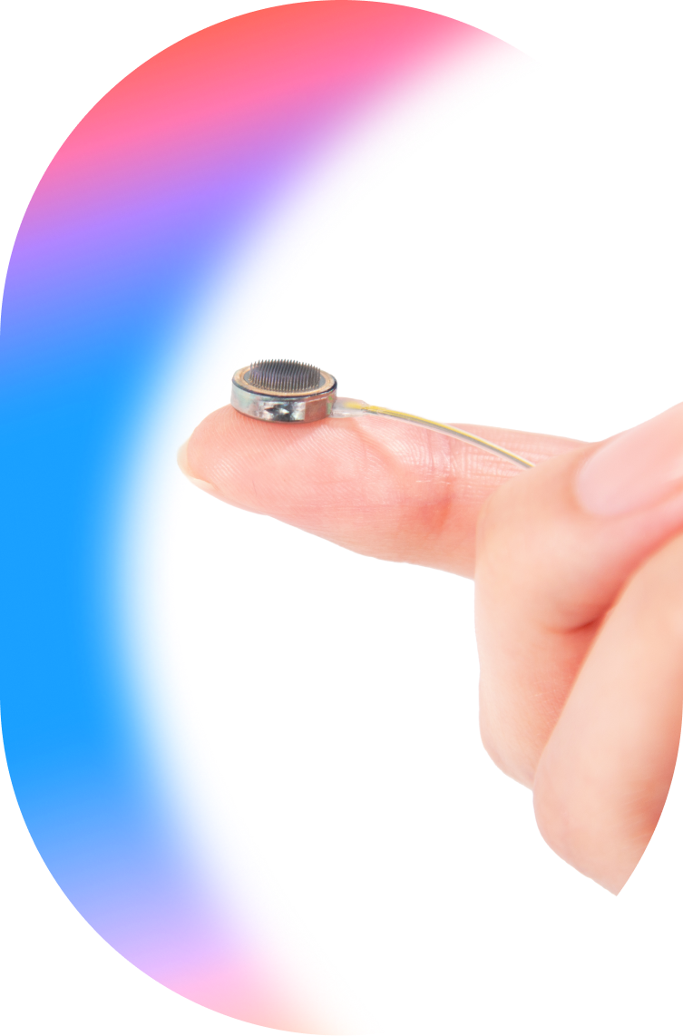 Female hand holding the Connexus Brain-Computer Interface Cortical Module on the tip of her finger for scale