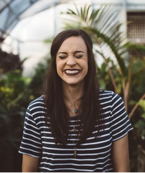 a woman with long hair smiling in a greenhouse - volunteer - best organization website webflow CMS template