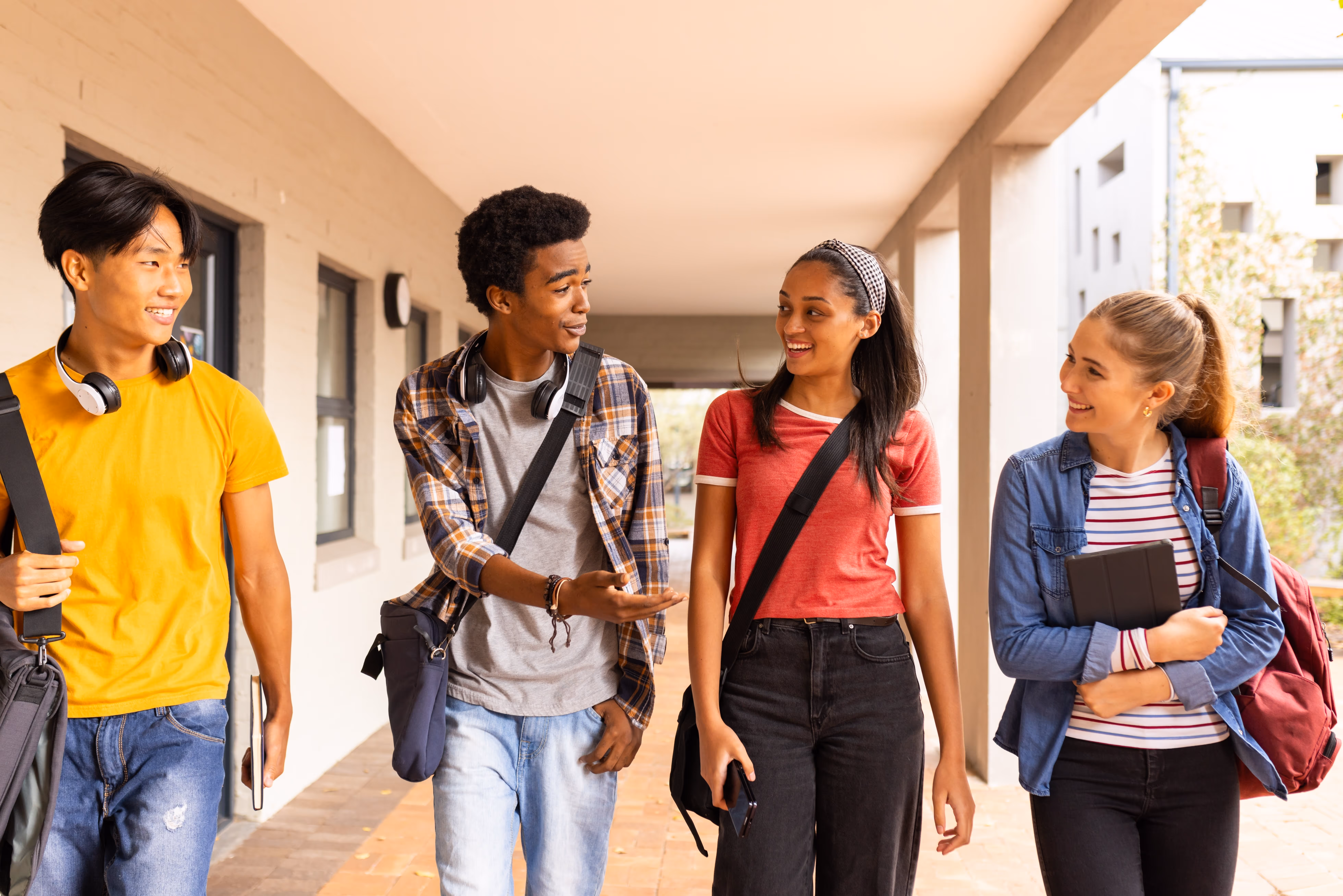 Smiling students walking down a hallway