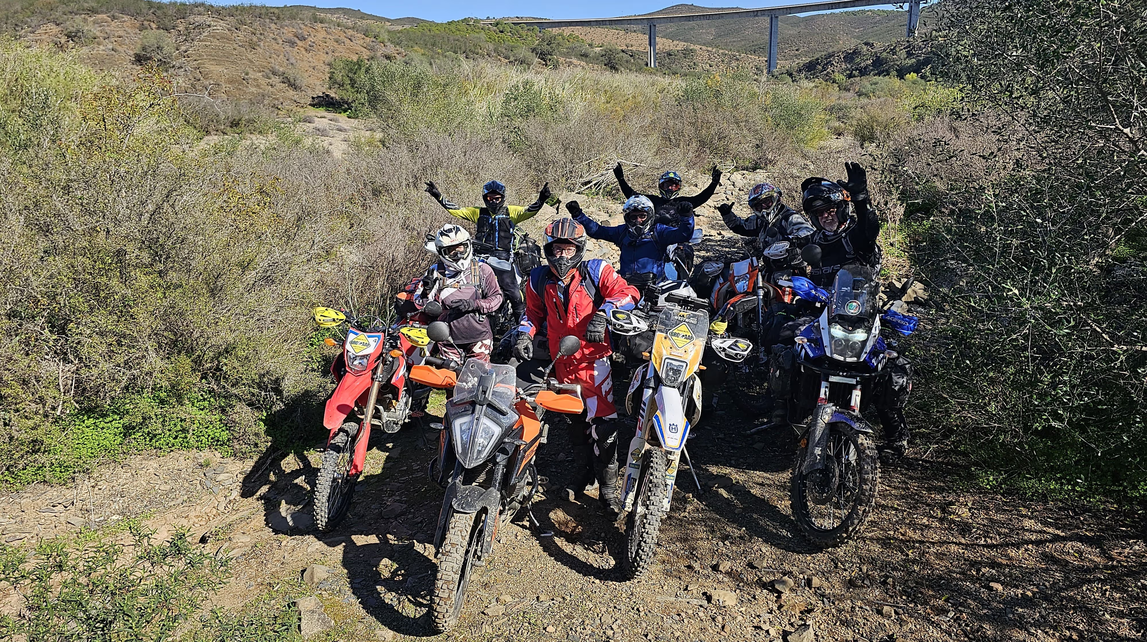Groupe de motards trail posant bras levés dans la garrigue