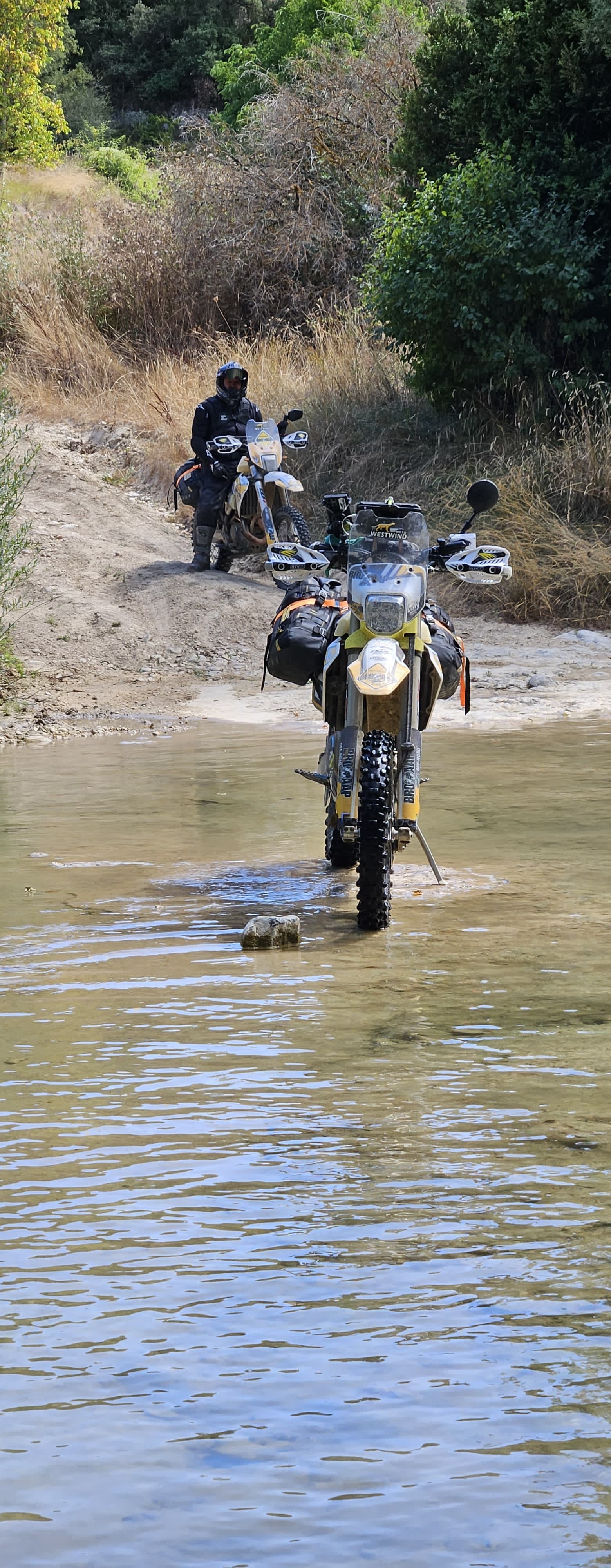 Motards trail traversant une rivière à gué