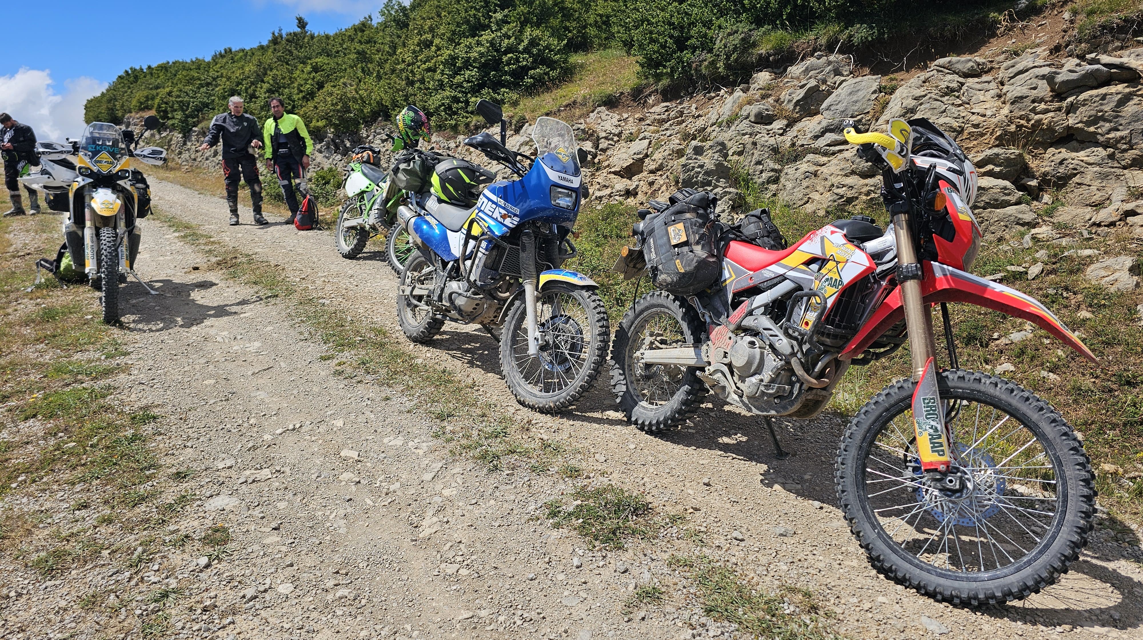 Motos trail alignées au bord d’une piste caillouteuse