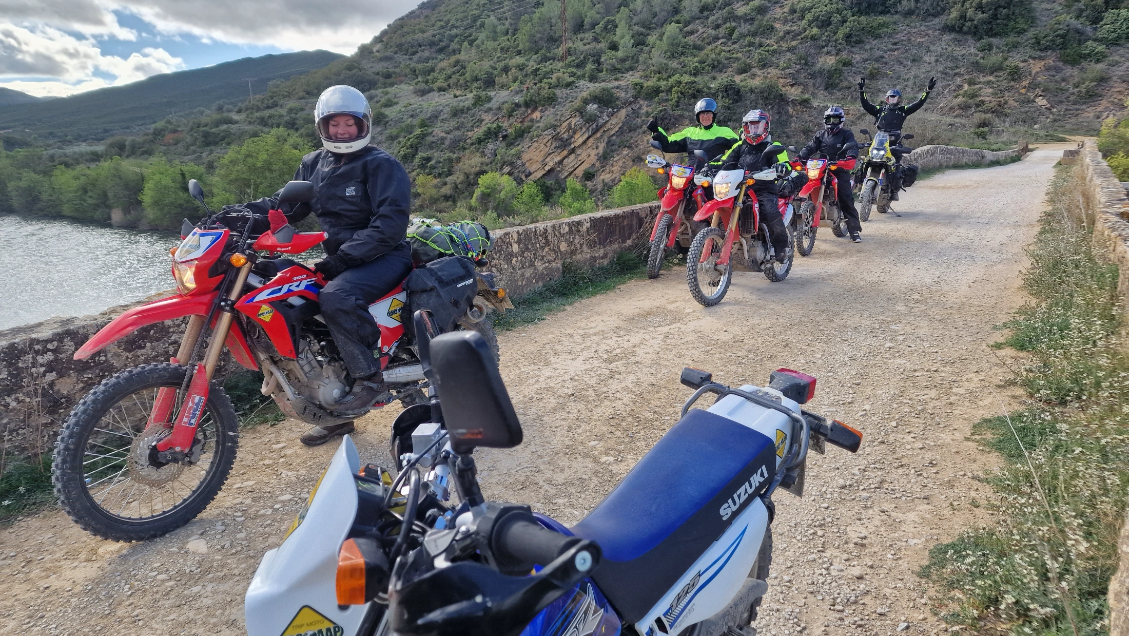 Groupe de motardes en moto d’enduro sur une piste au bord d’un lac