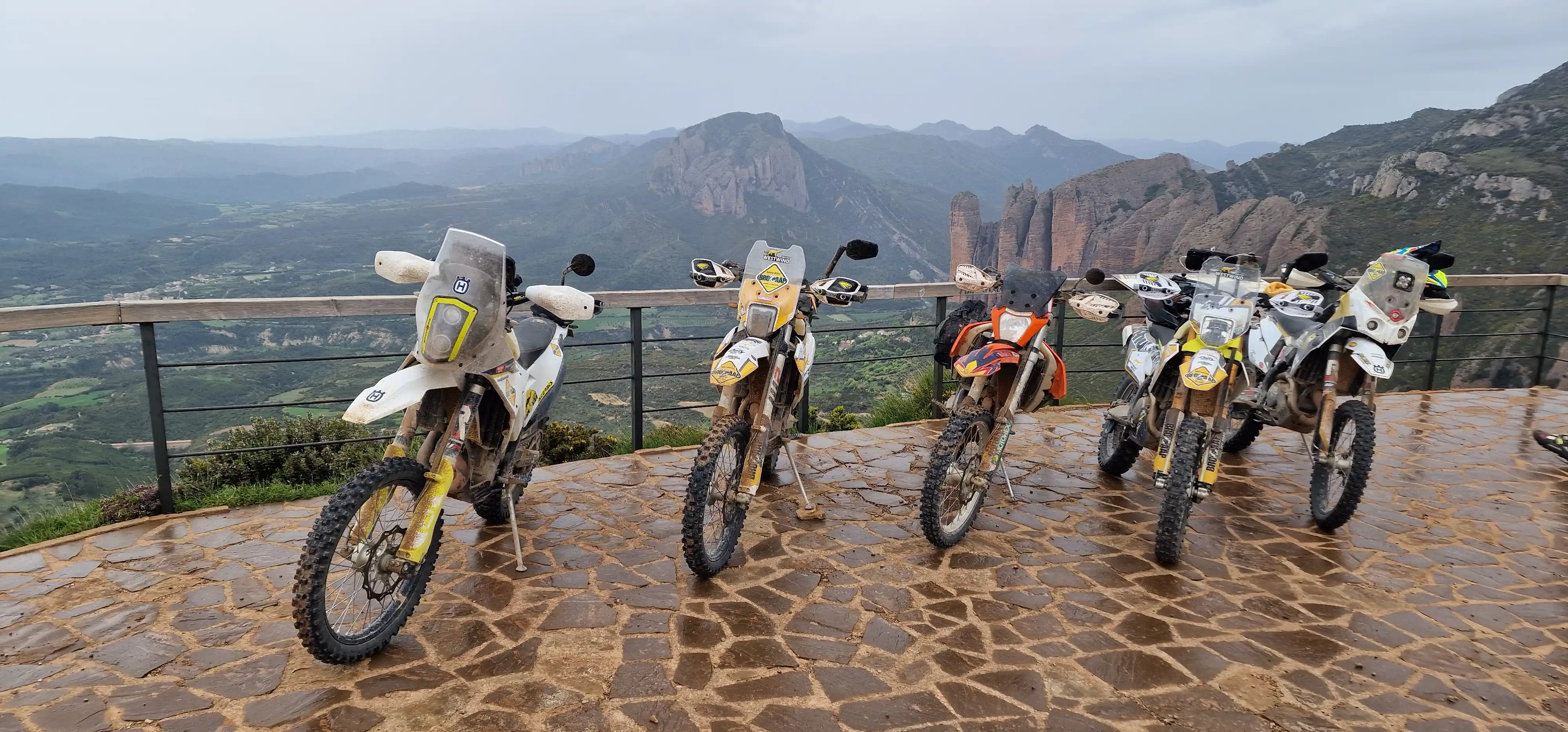 Motos trail alignées sur un belvédère face aux Mallos de Riglos