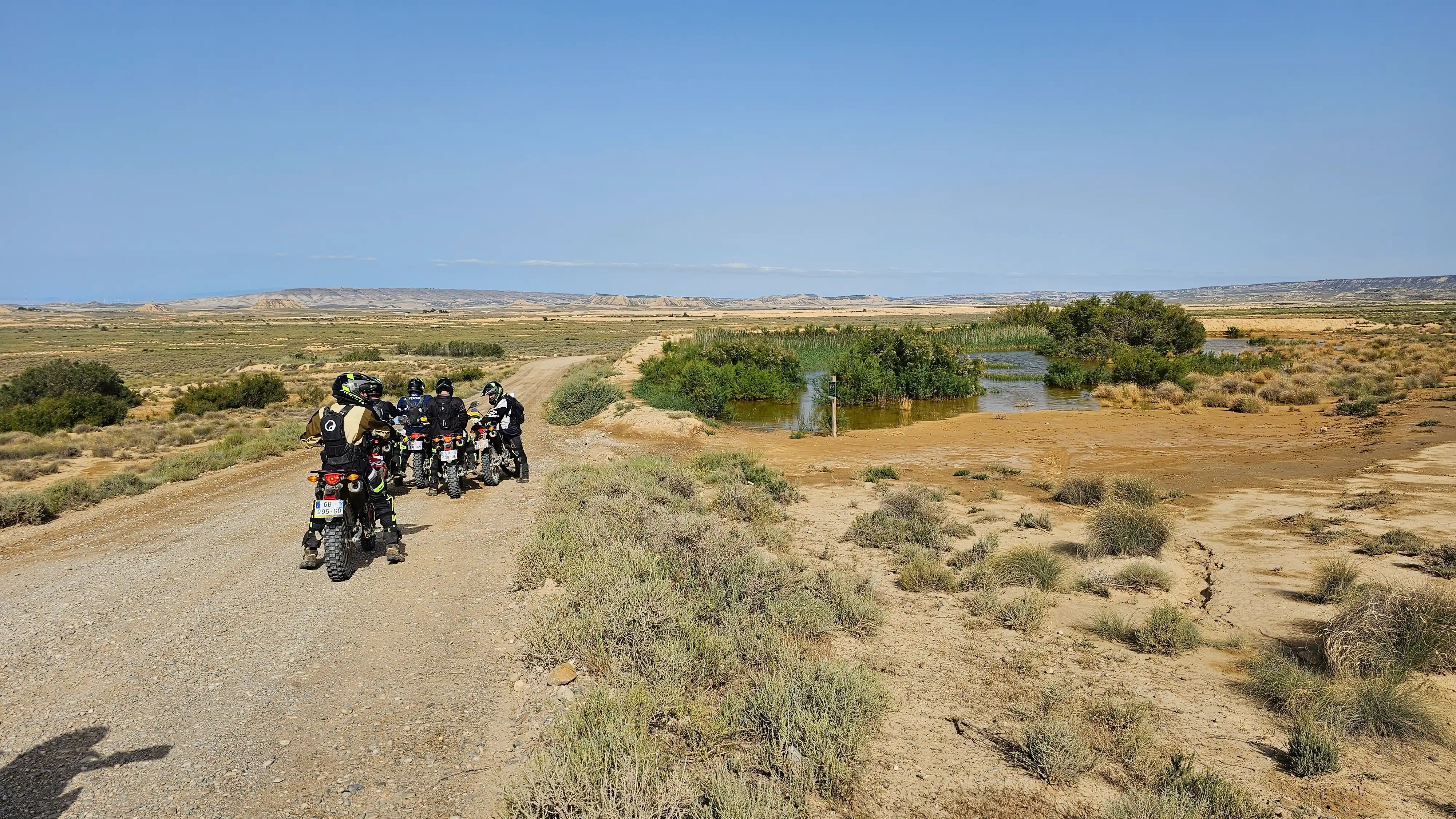 Groupe de motards trail sur une piste de terre en zone semi-désertique