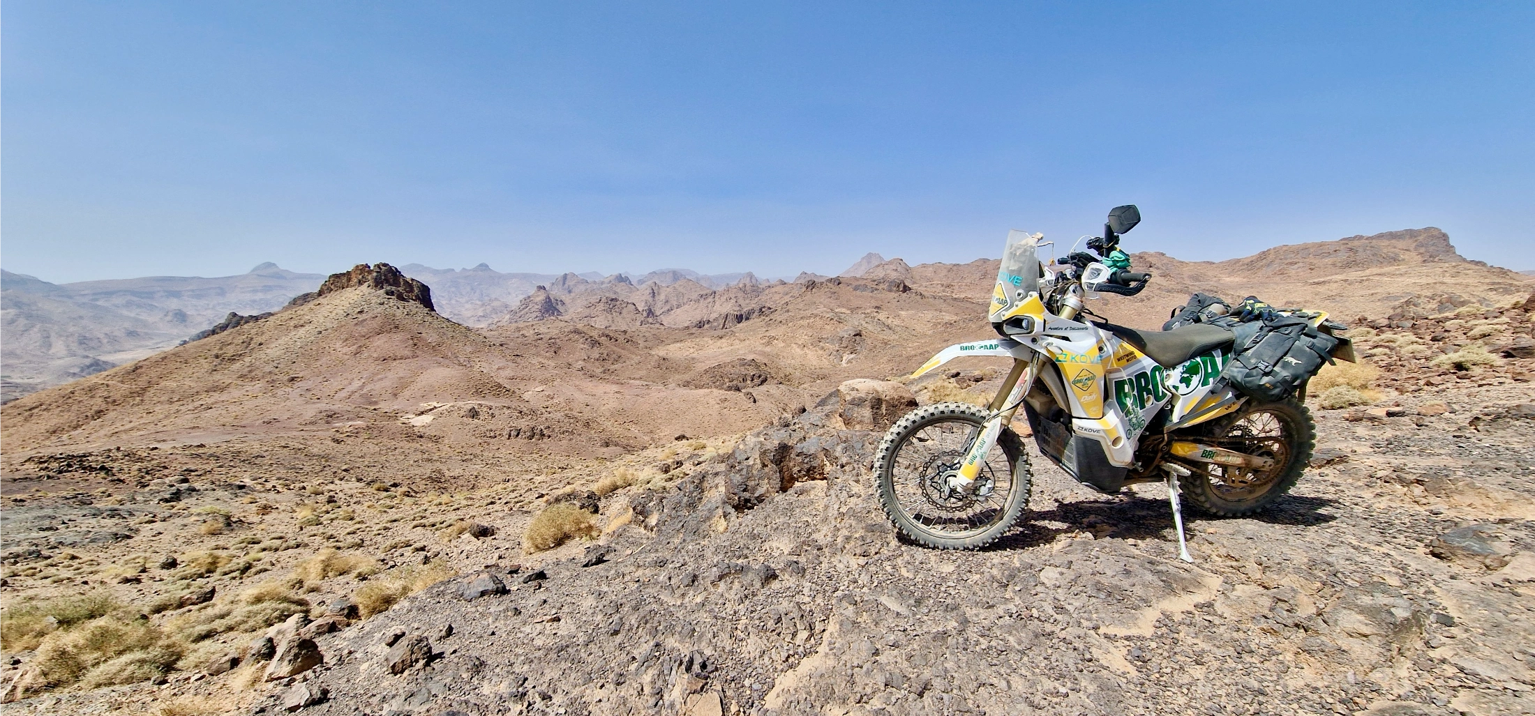 Moto trail Brooaap garée sur un promontoire rocheux au Maroc