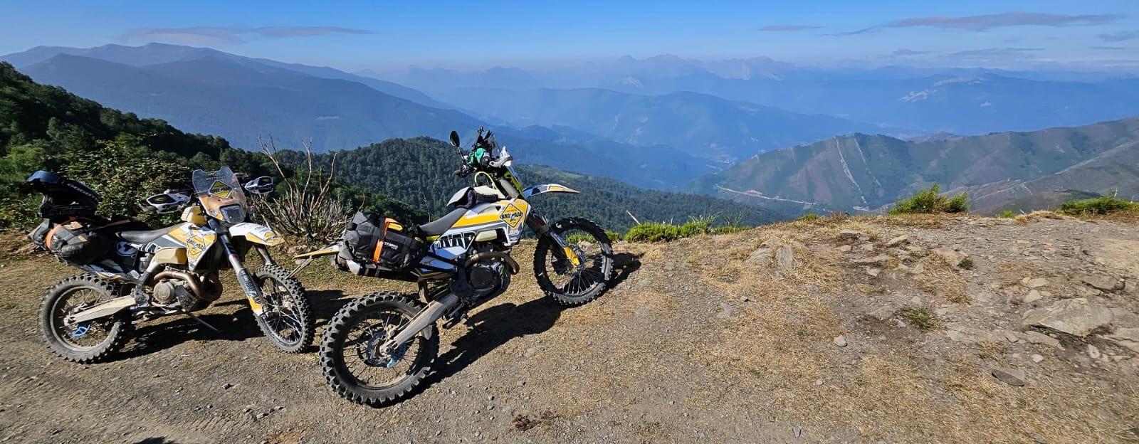 Deux motos trail garées sur un promontoire dominant les montagnes
