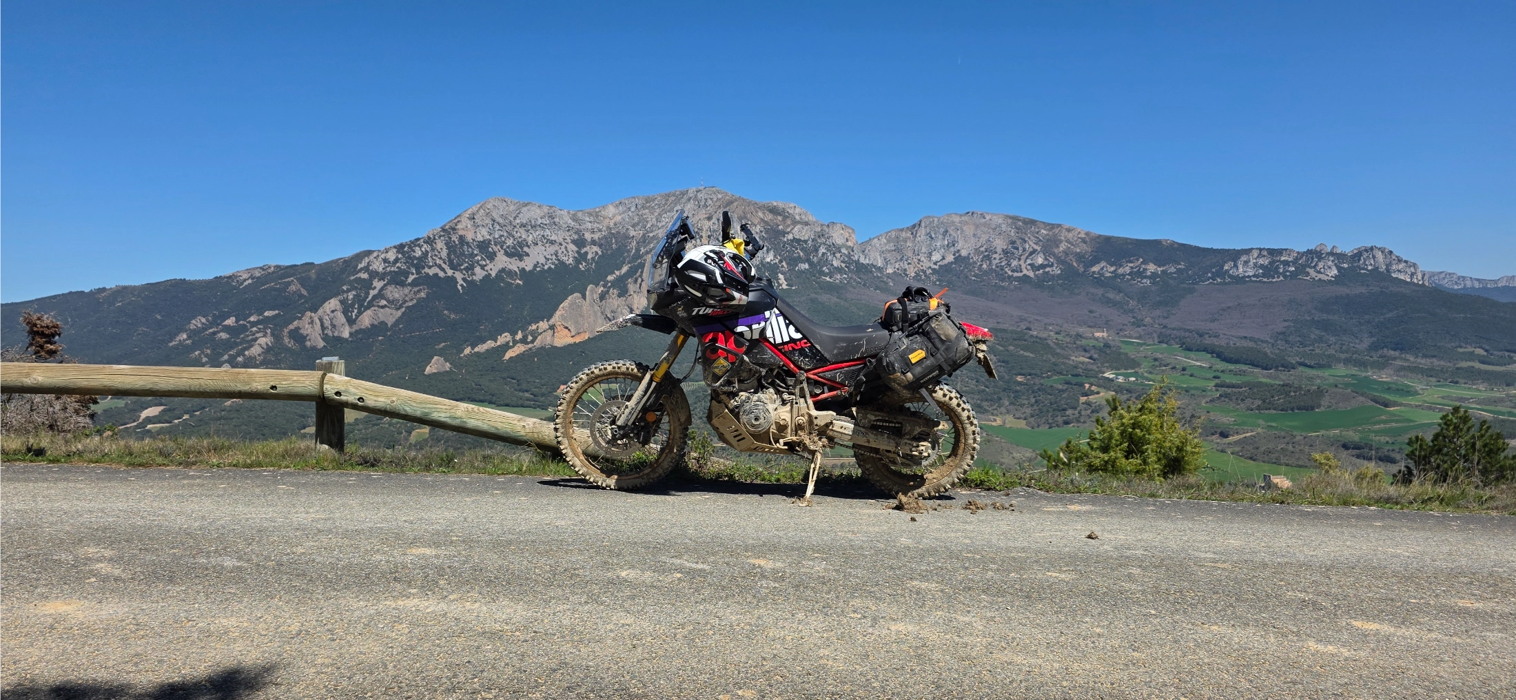 Moto trail garée au bord d’une route face aux montagnes