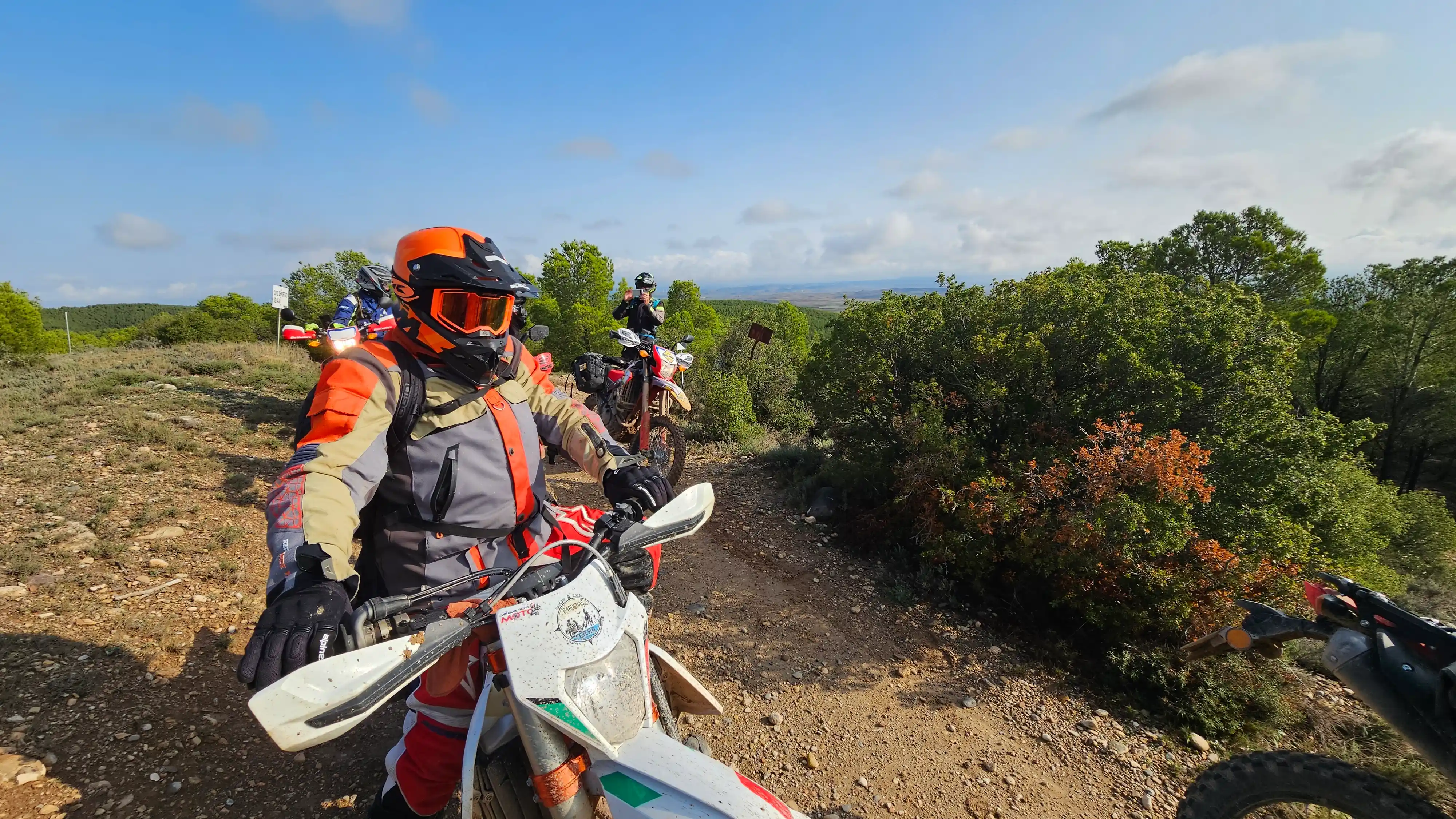 Motard d’enduro souriant sur un sentier dans la garrigue