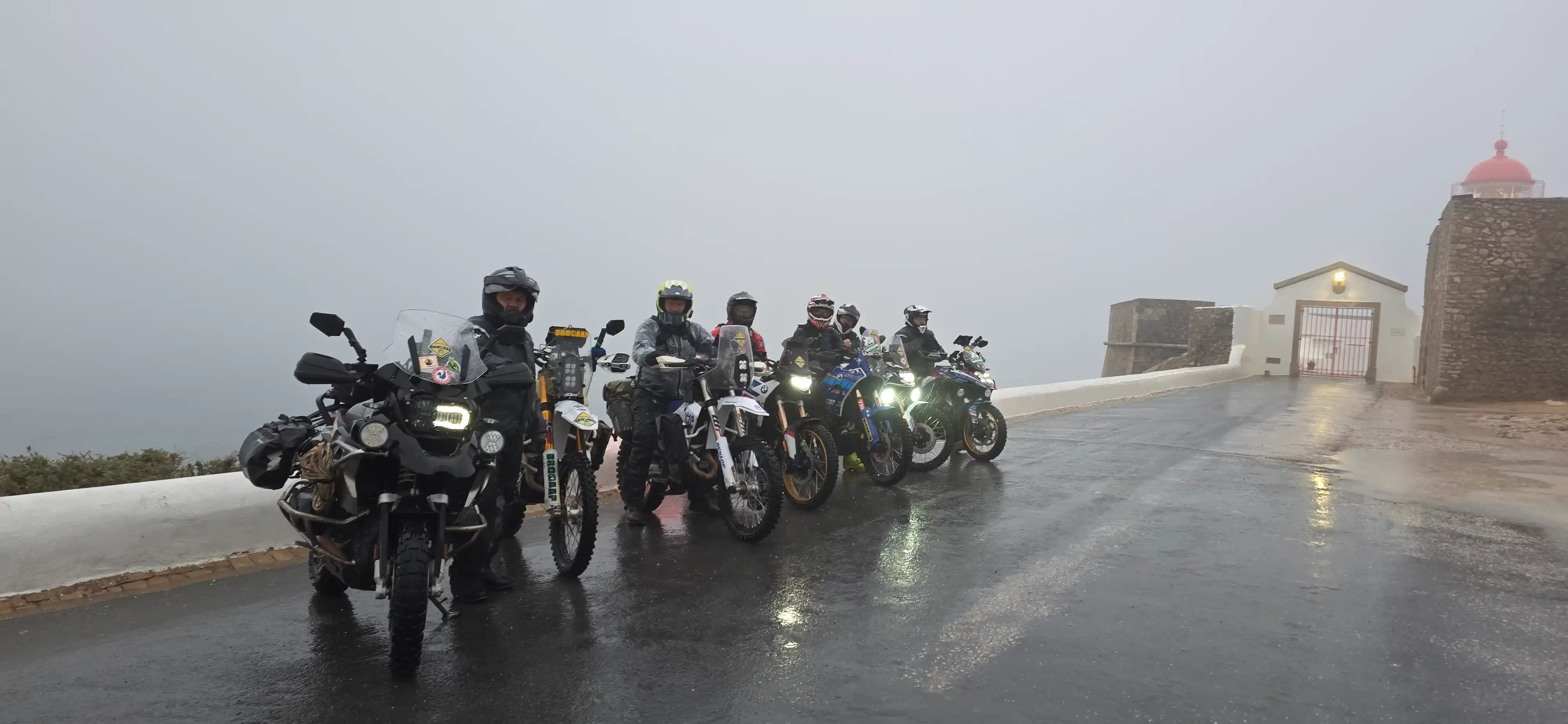 Motos trail sous la pluie près d’un phare dans la brume