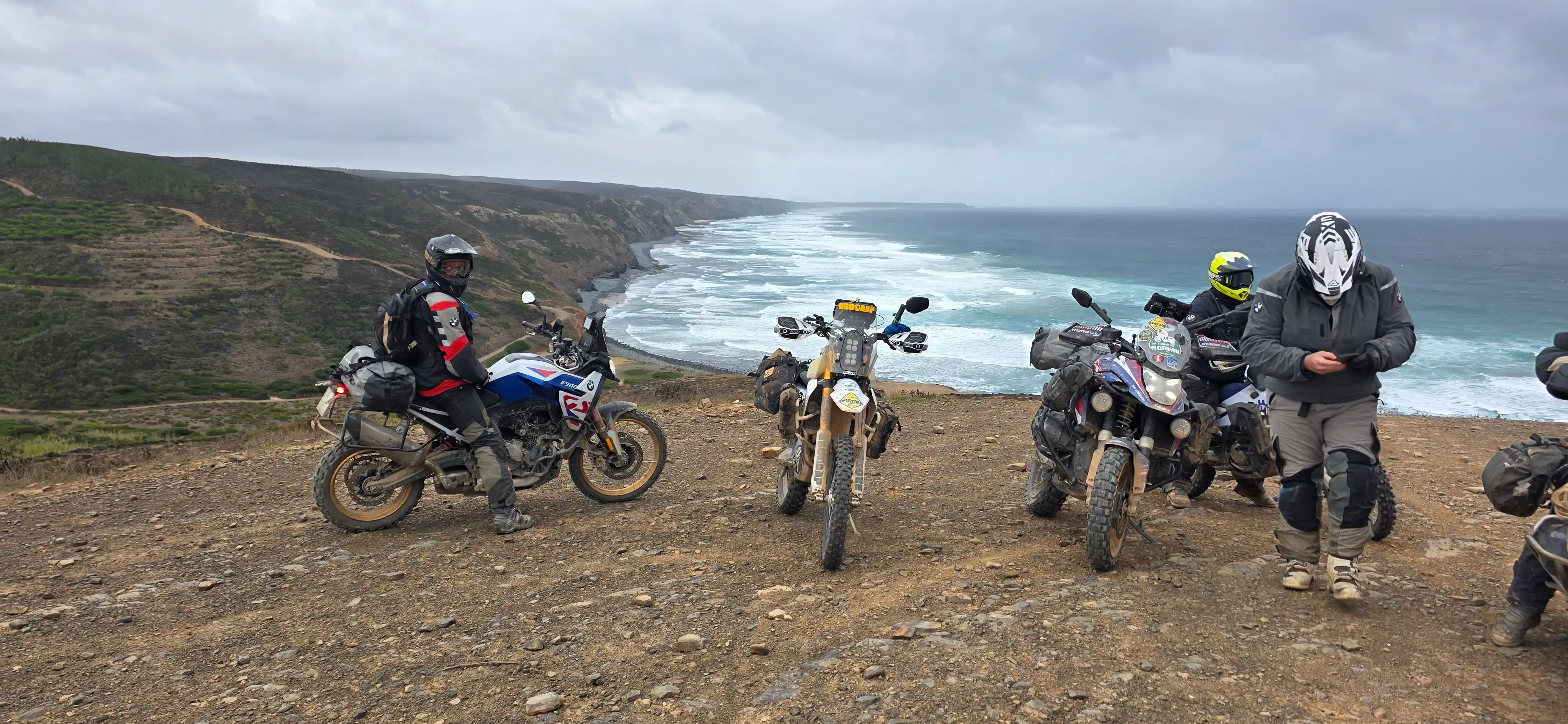 Motards trail à l’arrêt face à l’océan et aux falaises de l’Algarve
