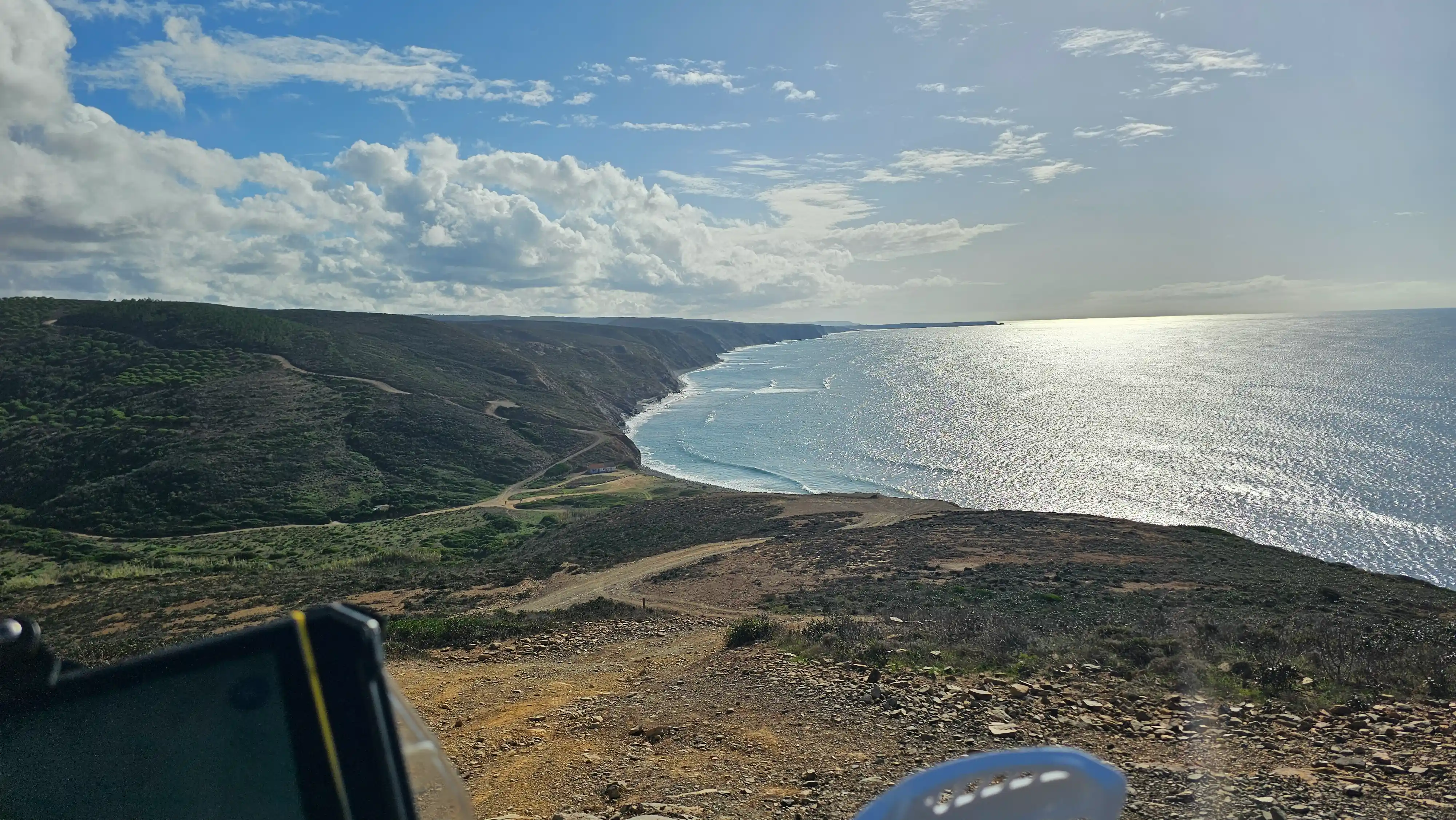 Côte et océan scintillant vus depuis une piste en hauteur