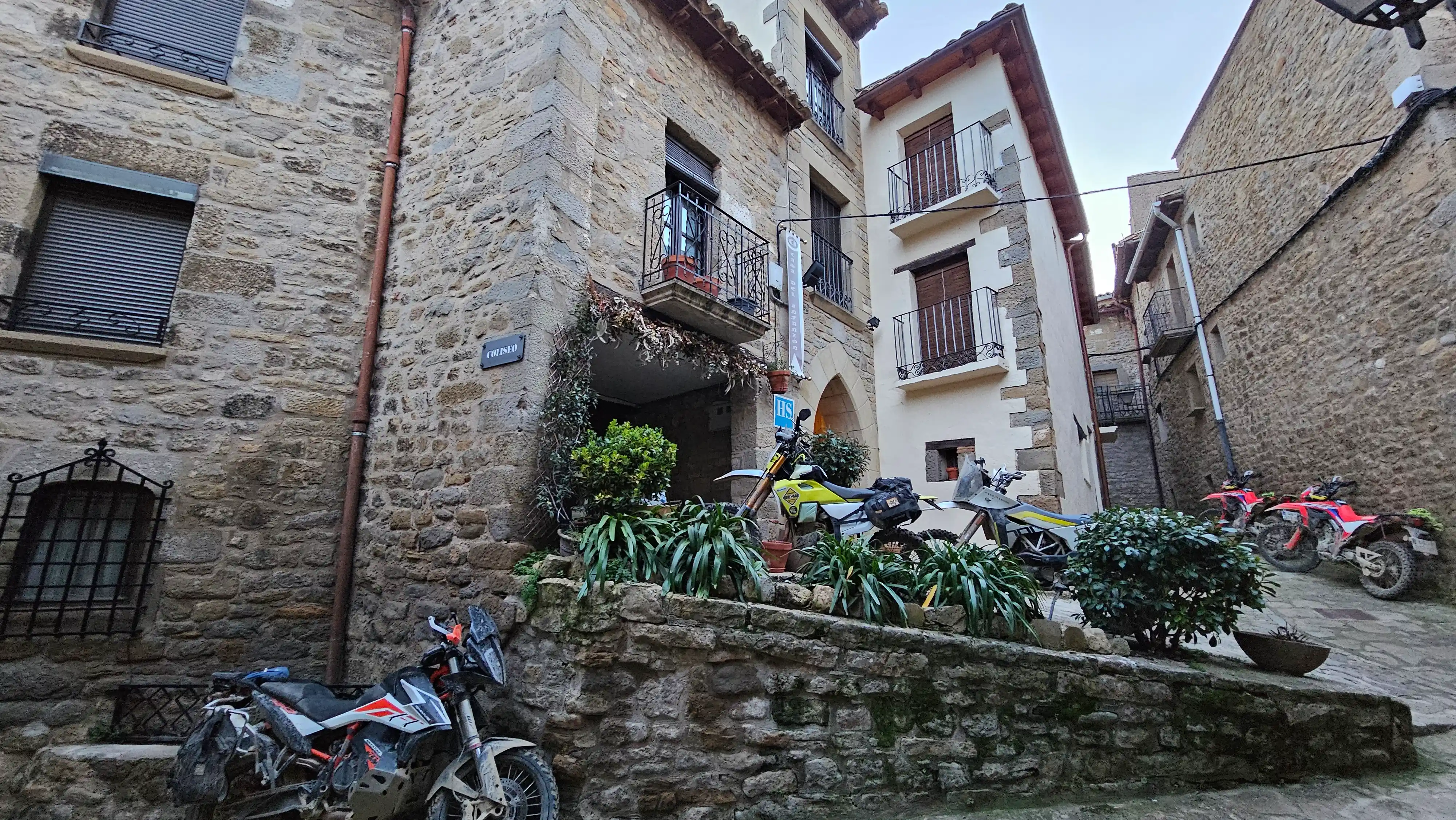 Motos garées dans une ruelle de village en pierre