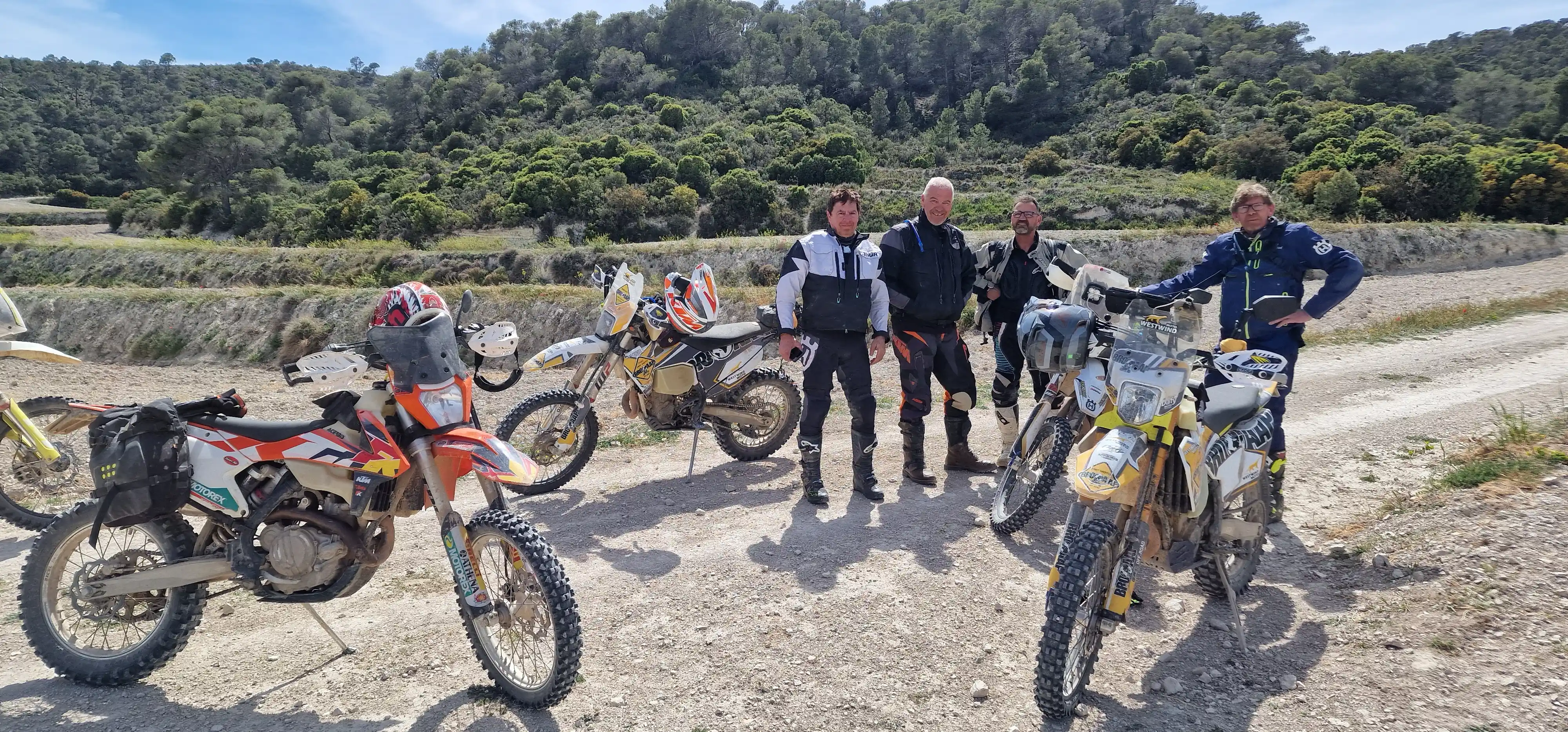 Groupe de motards et motos trail sur une piste de garrigue