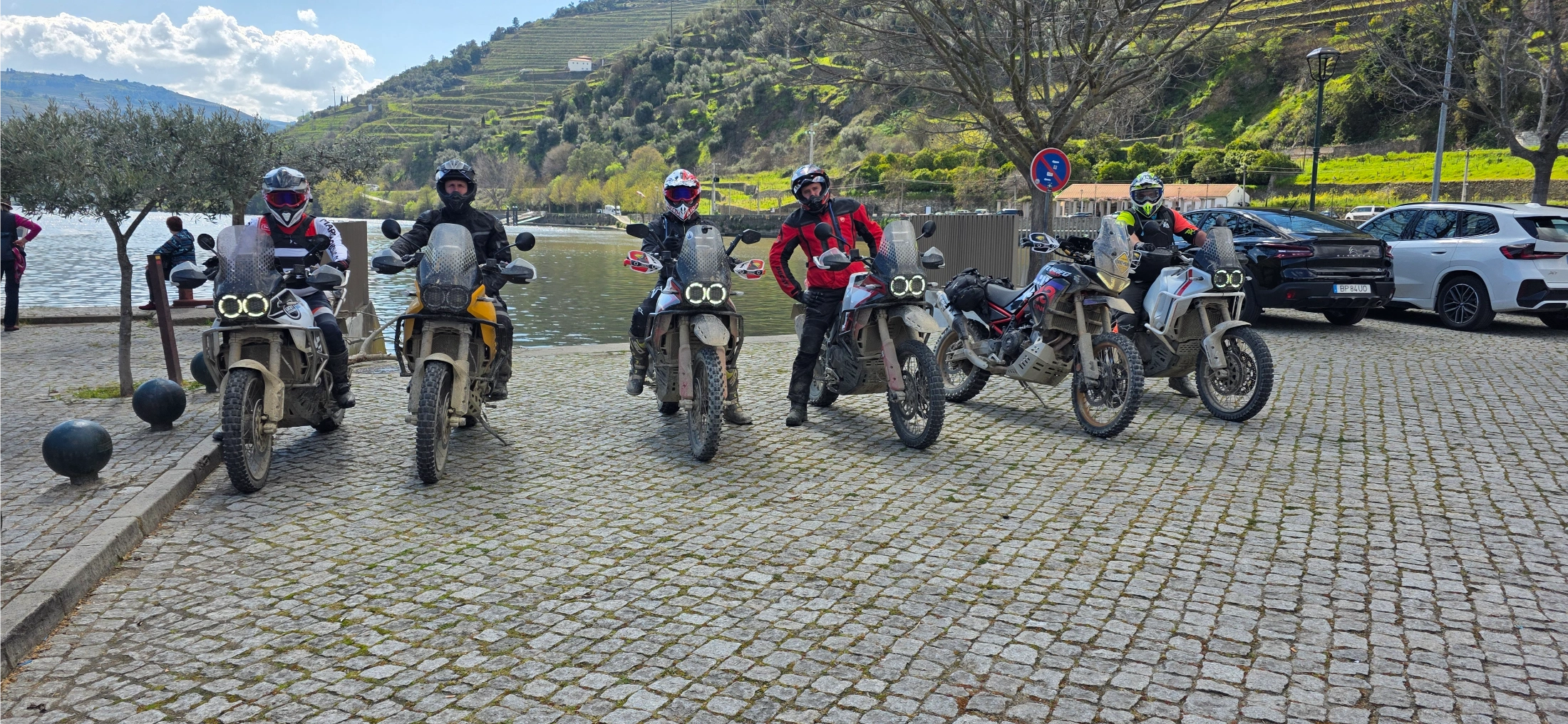 Groupe de motards et motos trail sur un quai pavé au bord du Douro