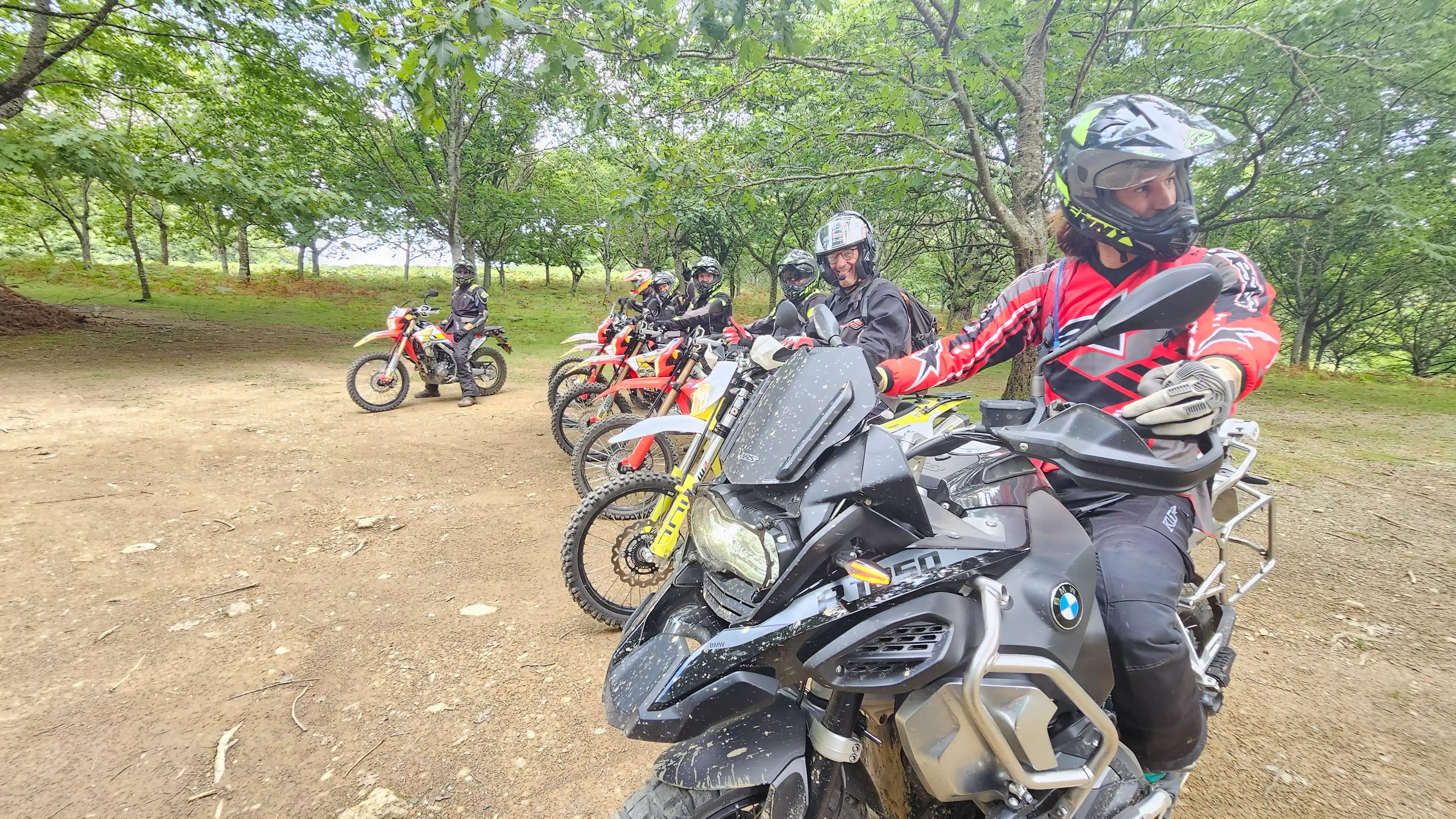 Groupe de motards trail à l’arrêt dans une clairière pendant un raid encadré