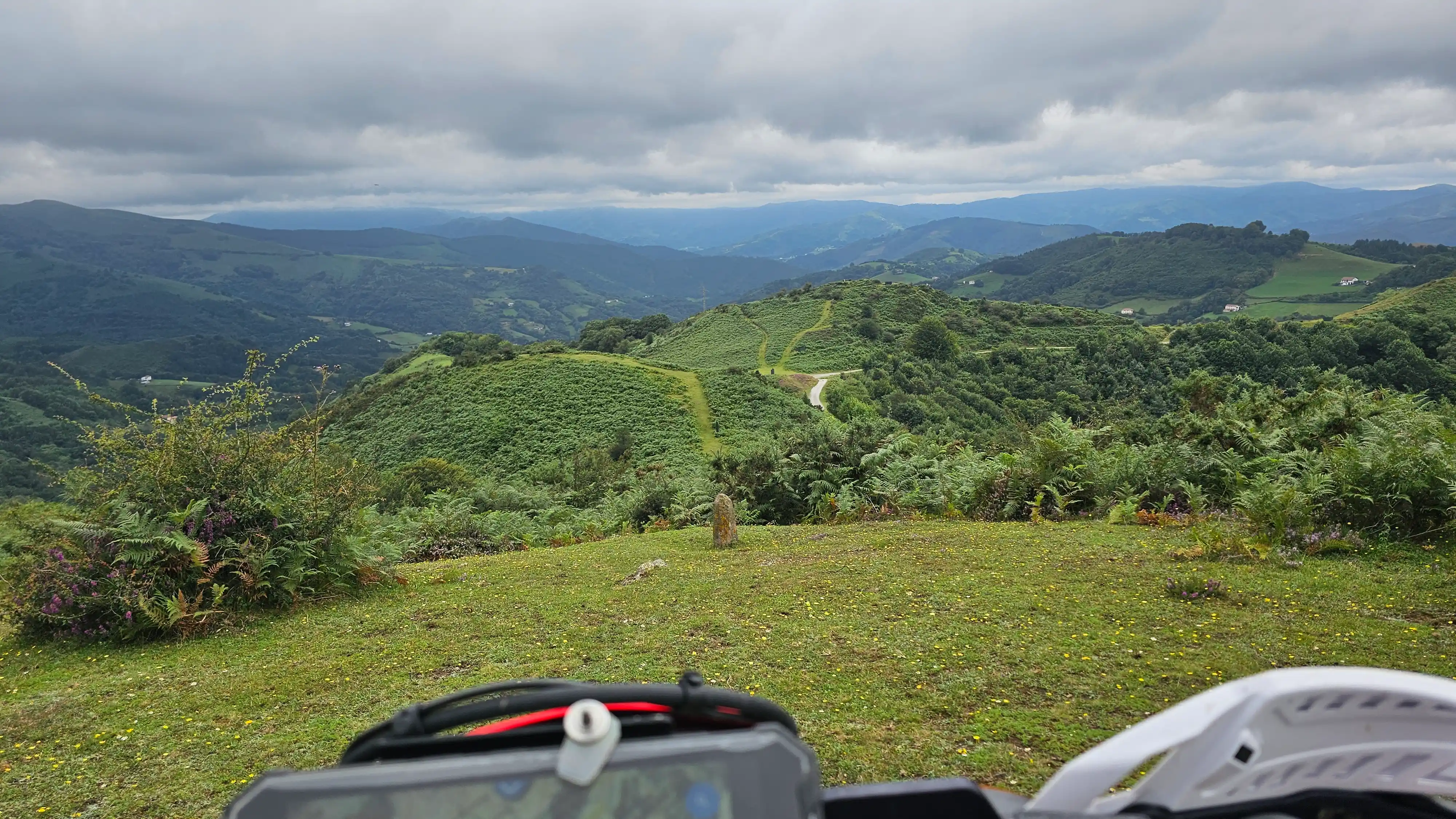 Collines vues depuis le guidon d’une moto trail pendant un raid
