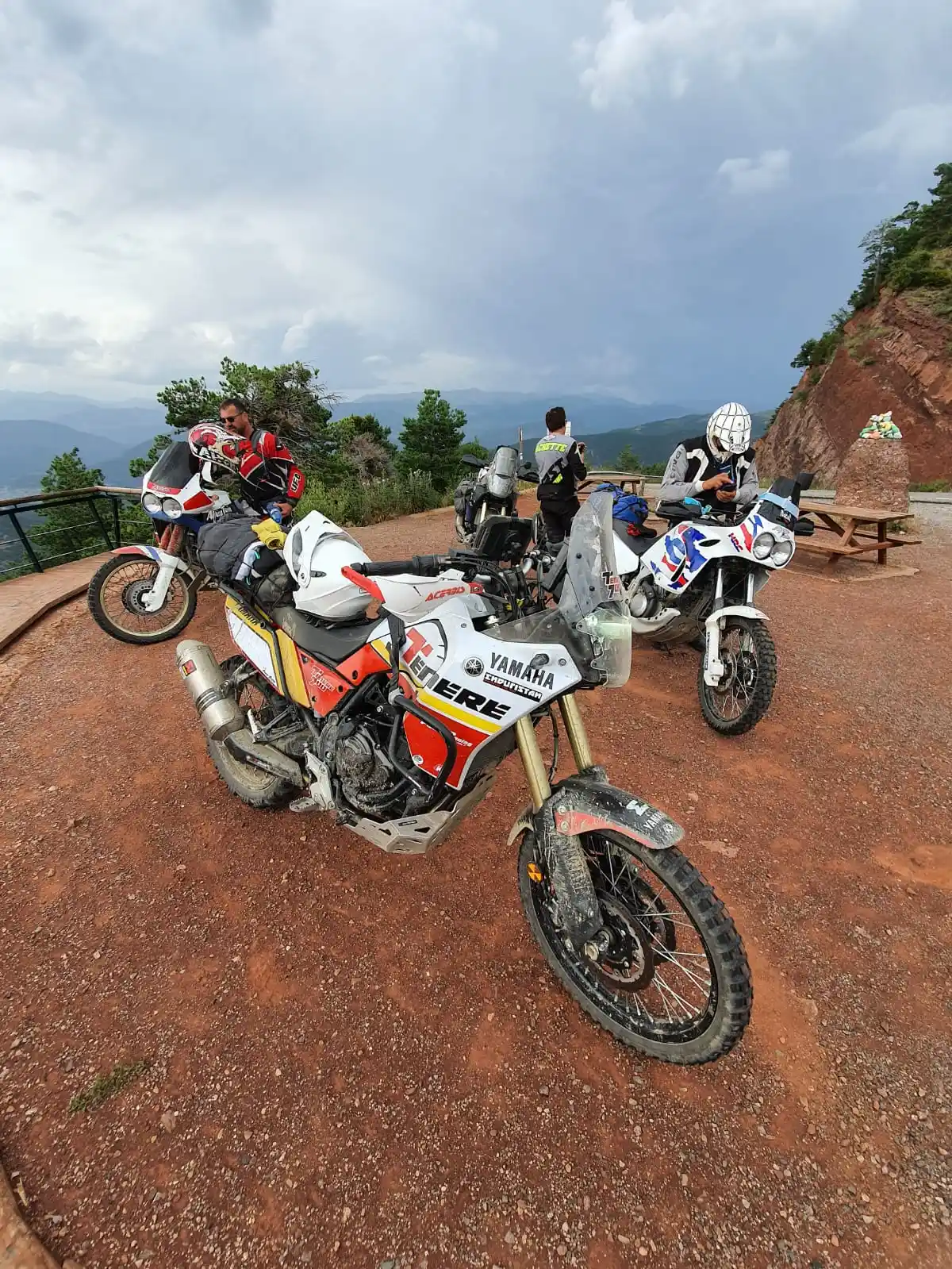 Motos trail garées sur un belvédère de terre rouge