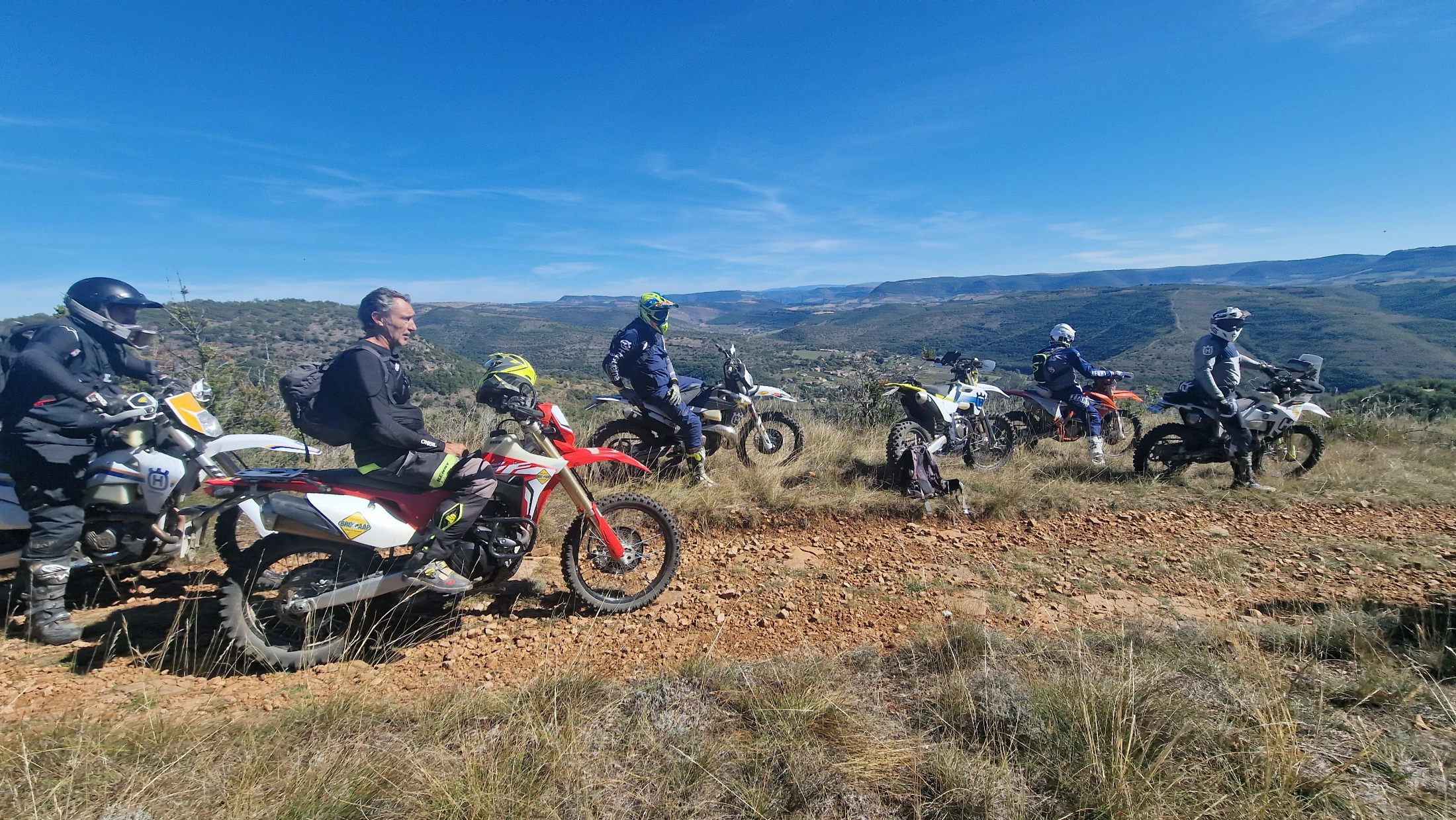 Groupe de motards trail sur un causse face aux gorges