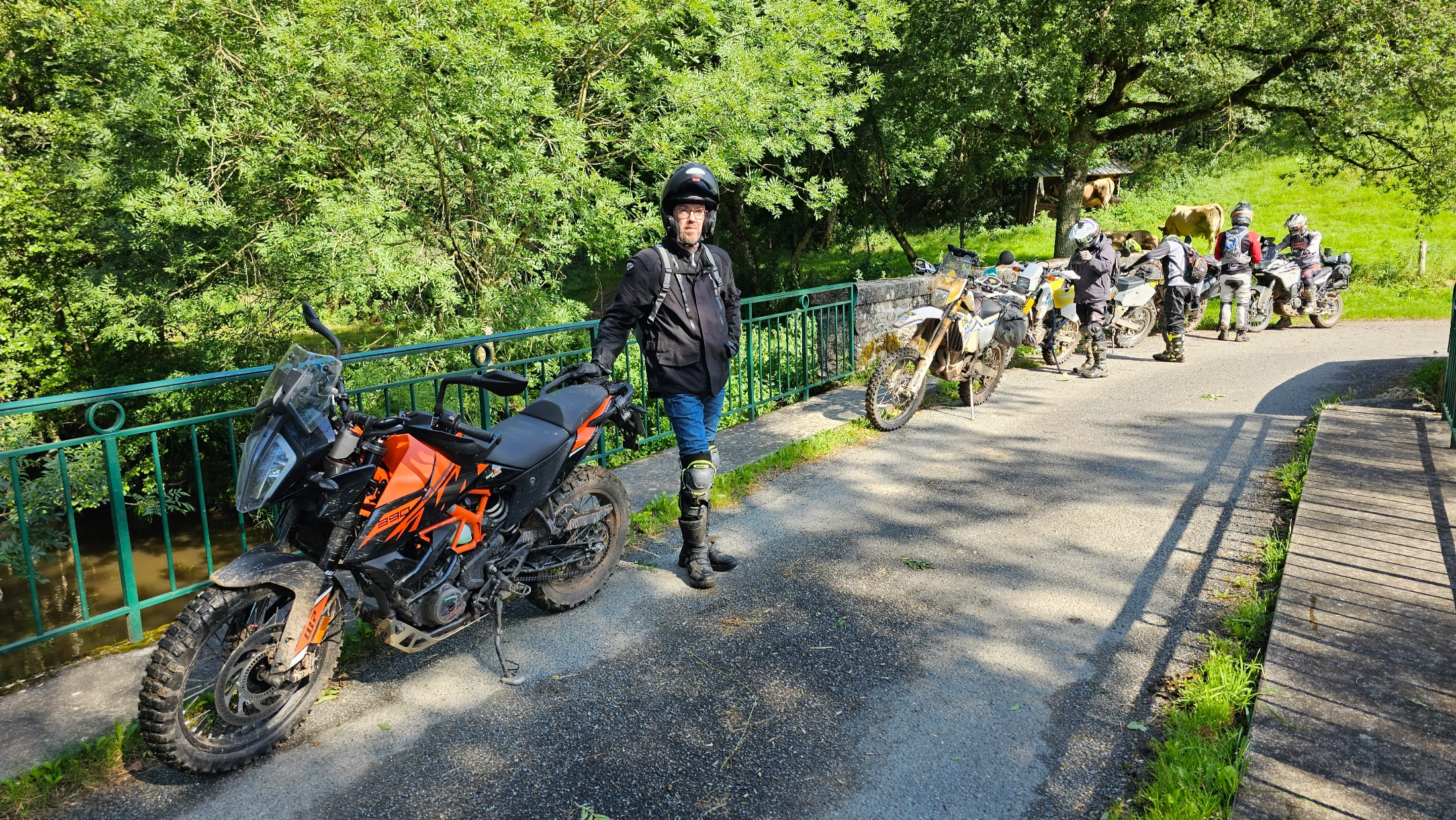 Motos trail garées le long d’une route ombragée dans l’Aveyron