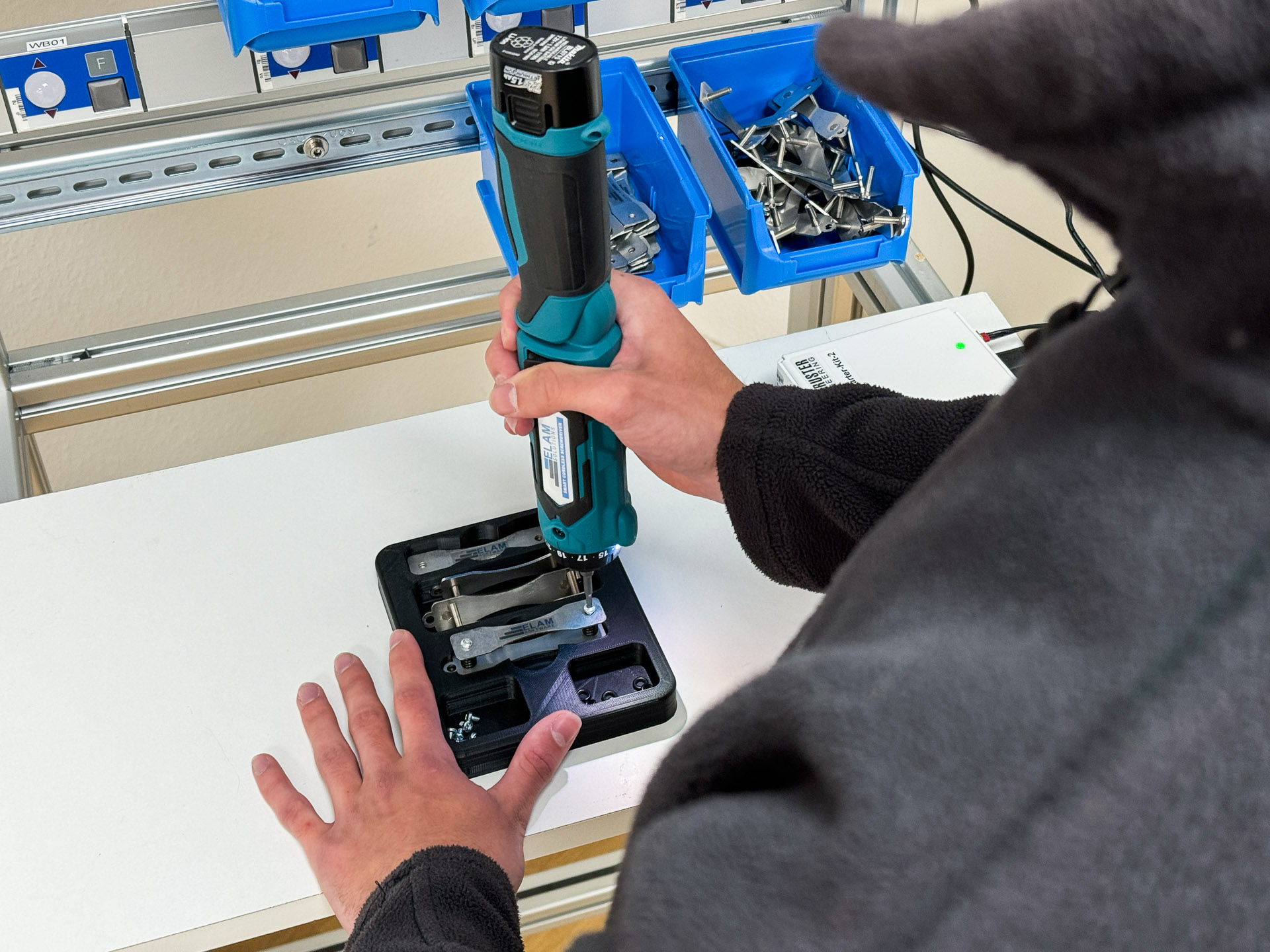 Nahaufnahme wie ein Mitarbeiter eine C-Verschraubung mit dem SMAC= 5 C-Schrauber und ELAM Solutions Werkerassistent vornimmt.