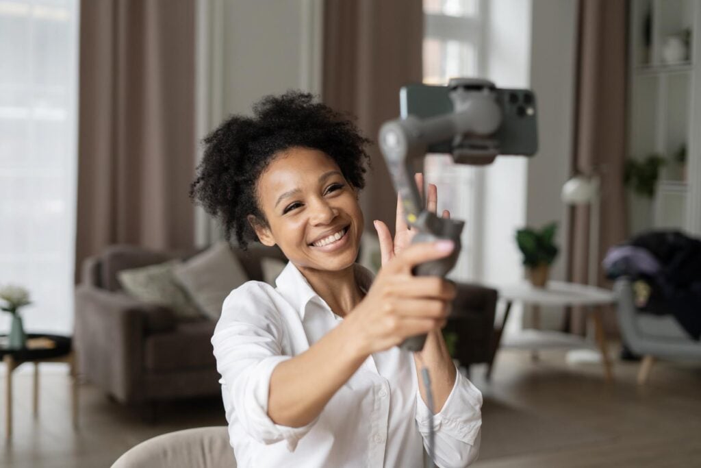 Influencer using a ring light and phone on tripod to make UGC for a skincare serum.