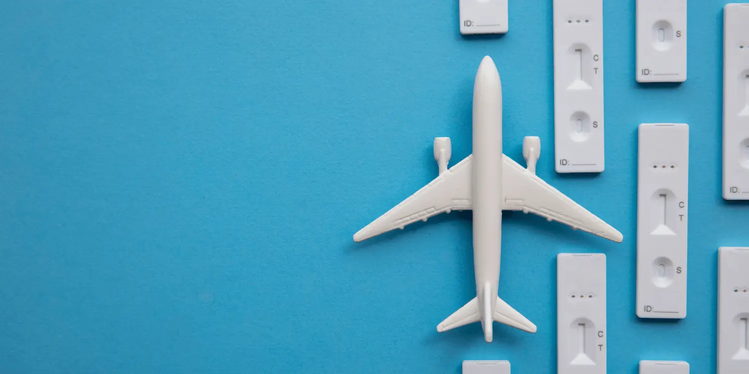 A white airplane that is above a blue background.