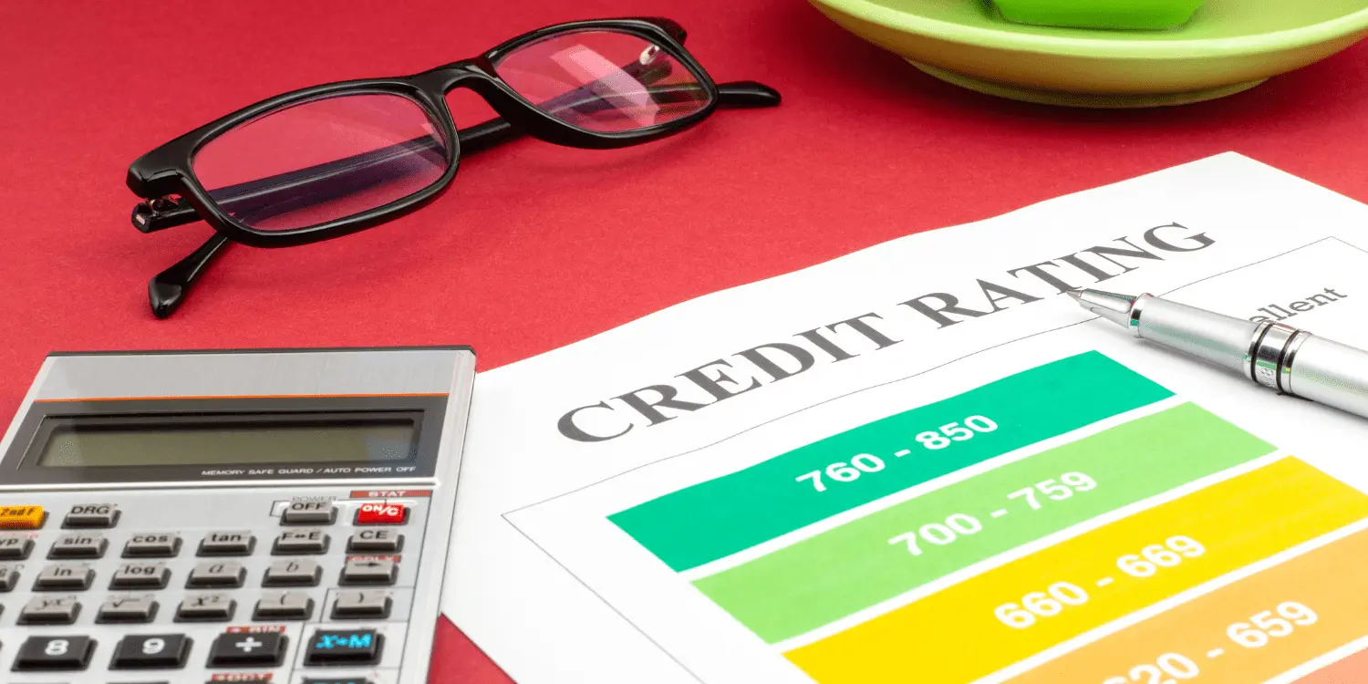 A calculator, pen, glasses, and a credit rating sheet used for writing a credit report personal statement.
