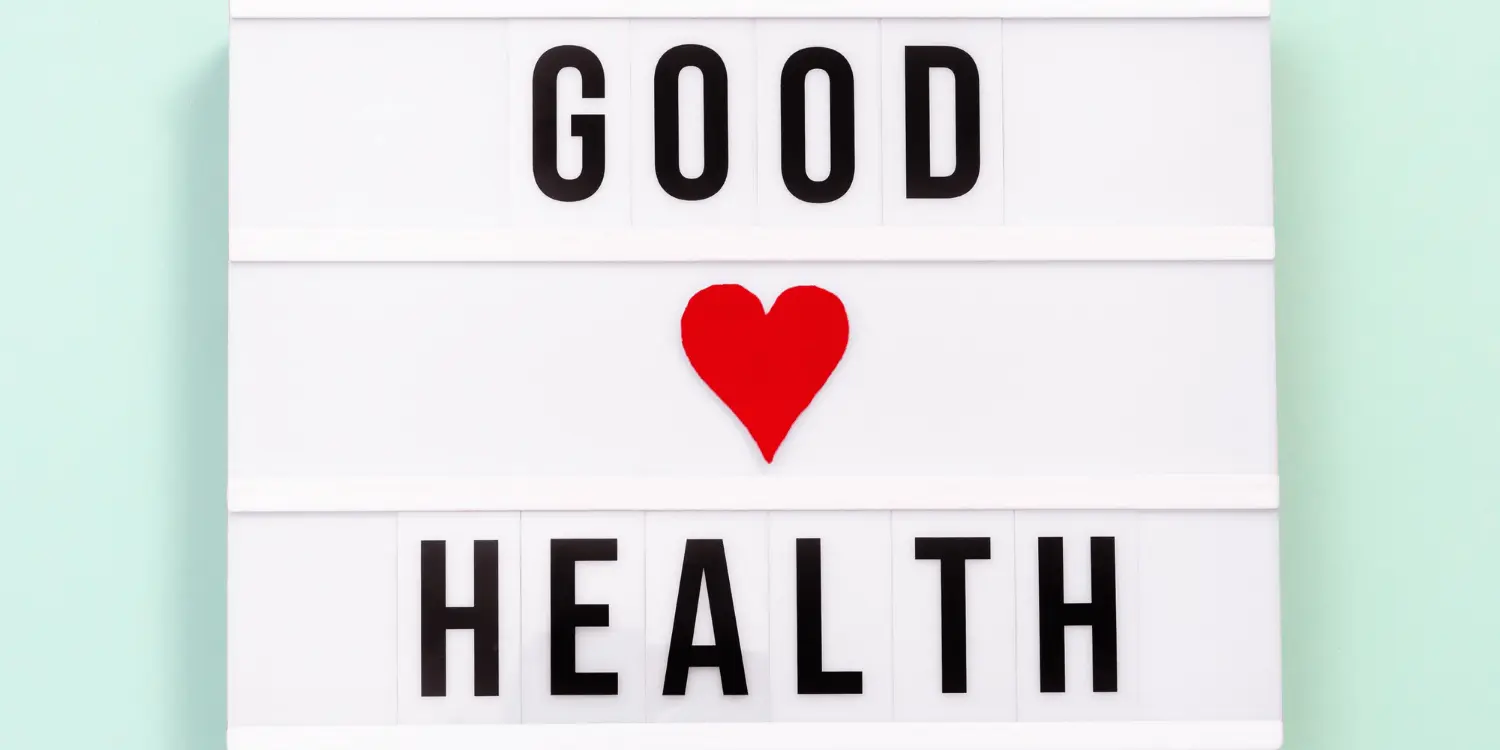 Un letrero que dice «bueno, forma de corazón en el centro y salud», que ilustra la compasión por la salud mental durante las fiestas.