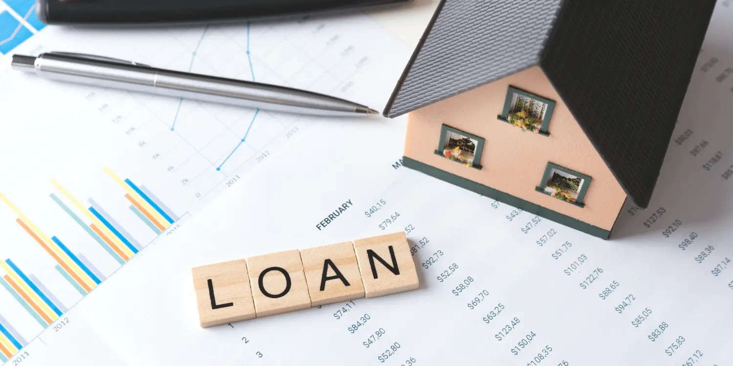 A house and loan details on paper representing home loan qualification.