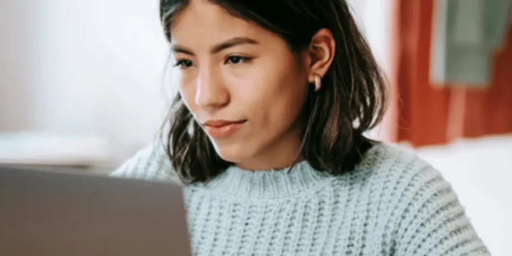 A person on the computer searching for how to defer car payments.