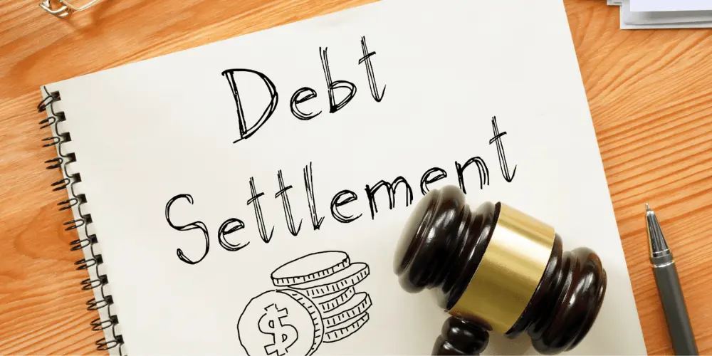 A paper that states "debt settlement" with a gavel on-top of it which illustrates that the debt has been settled legally.
